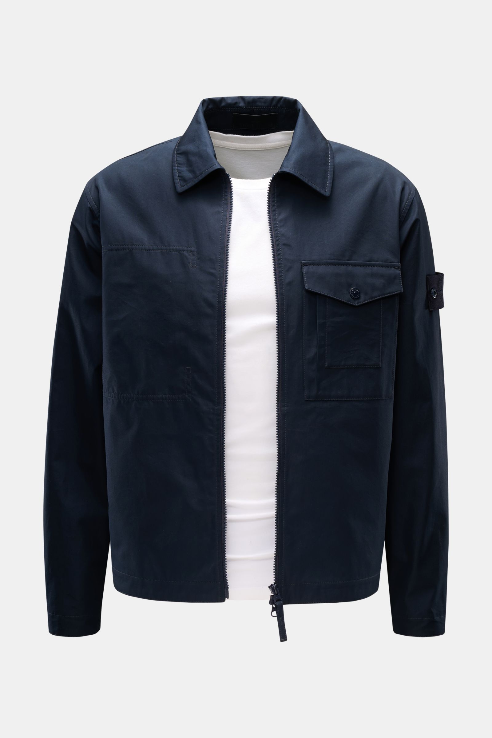 Front view of Stone Island Overshirt 'Ghost Piece' navy in dense woven pure cotton canvas, slim fit, with wind- and water-repellent fabric, robust two-way zipper, turn-down collar, buttoned chest flap pocket, tonal badge on upper arm, and buttoned sleeve 