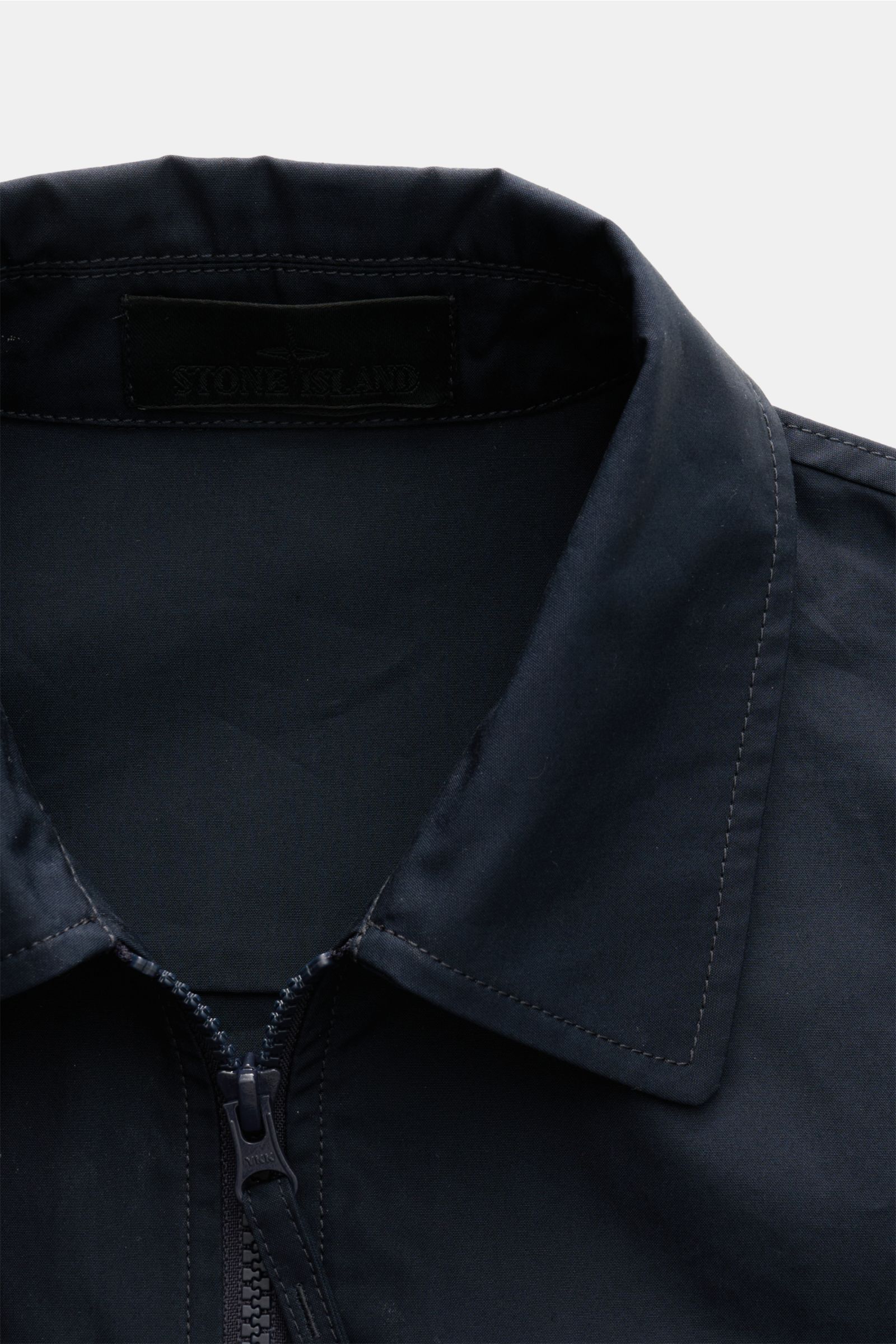 Stone Island Overshirt 'Ghost Piece' navy shown from close-up front top view, made of pure cotton canvas with smooth feel, wind- and water-repellent, slim fit, robust two-way zipper, turn-down collar, chest pocket with flap, tonal badge on upper arm, and 