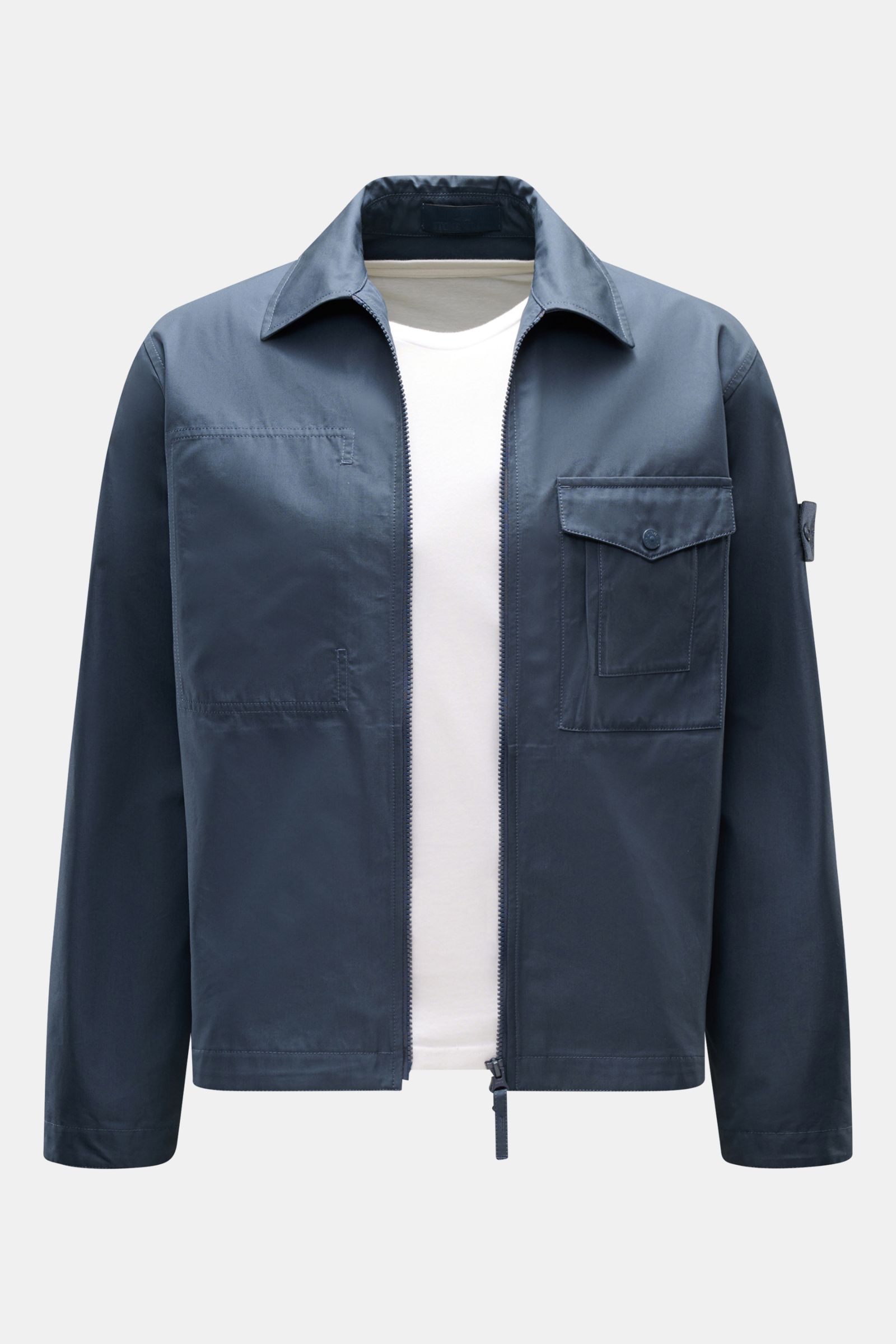 Stone Island Overshirt 'Ghost Piece' graublau shown from the front on a white background, slim fit cotton canvas with zip, collar, buttoned chest pocket, tonal badge, and buttoned cuffs. Funktion trifft Komfort: Das STONE ISLAND Overshirt aus der 'Ghost' 