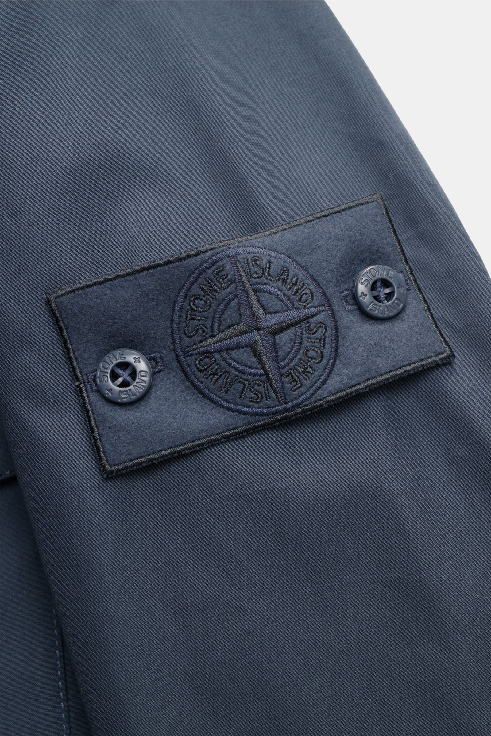 Stone Island Overshirt 'Ghost Piece' graublau, Detailaufnahme des tonalen Badges am Oberarm aus wind- und wasserabweisendem Baumwollcanvas