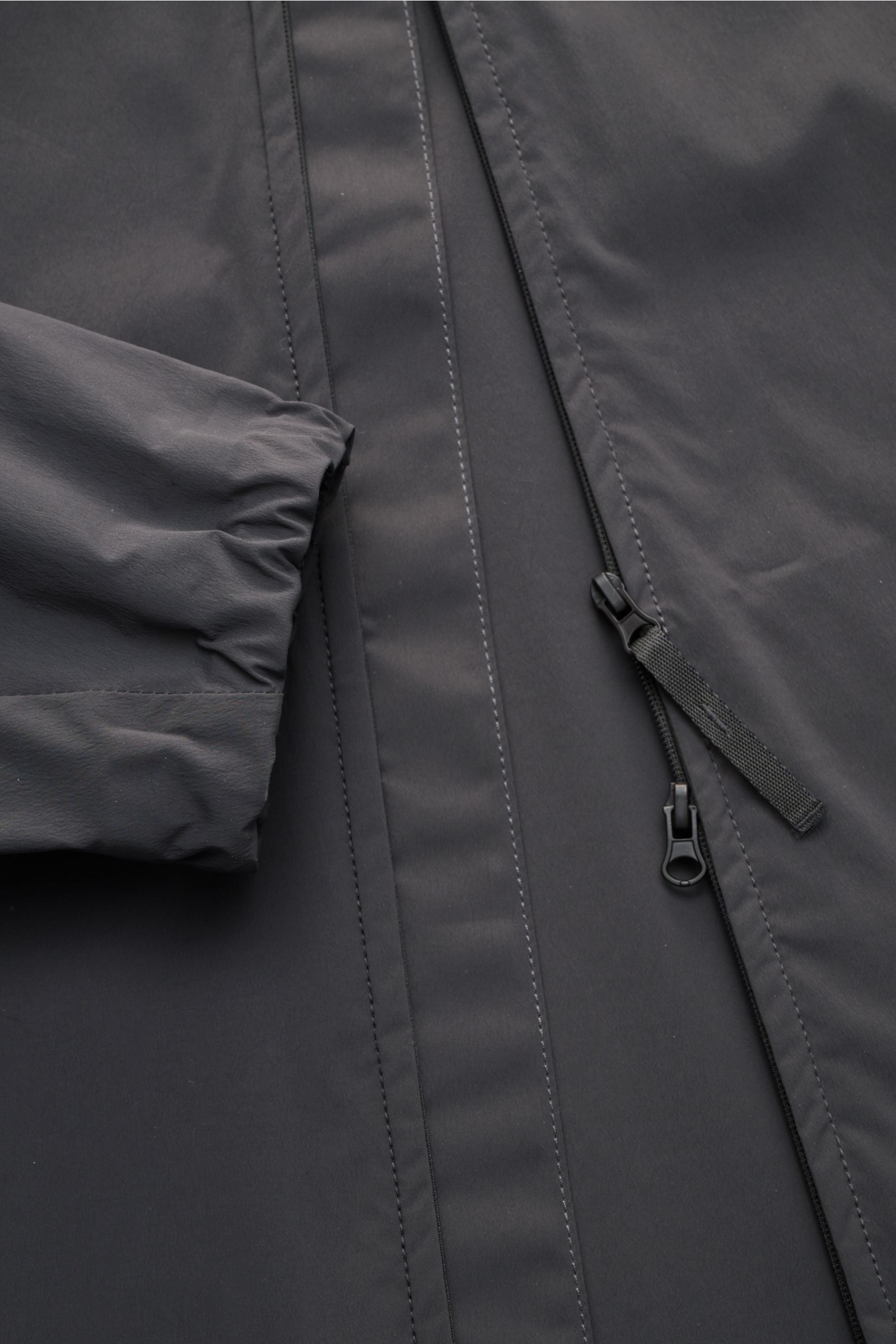 Stone Island Jacke 'Stellina' dunkelgrau, Detailaufnahme von vorne, glatte Microfaser, Zwei-Wege-Reißverschluss, elastische Ärmelbündchen.
