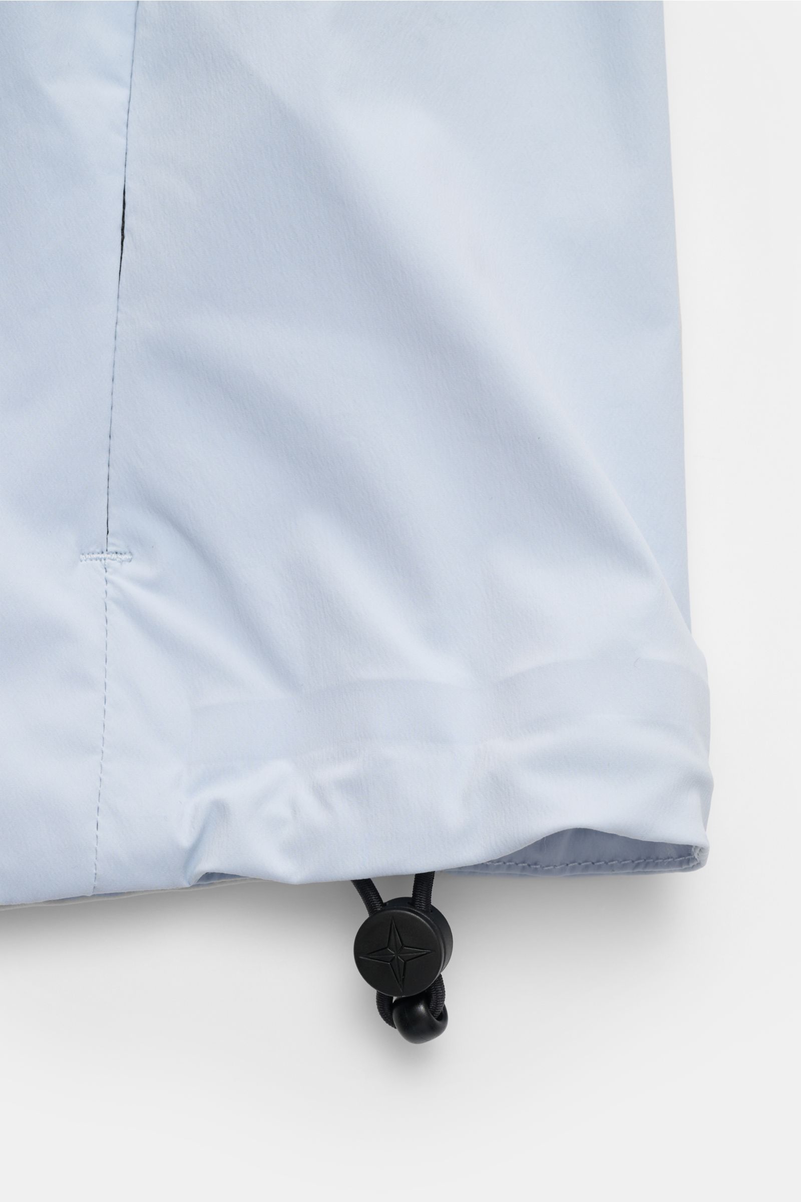 Close-up of the adjustable hem with cord lock on the Stone Island Jacke 'Stellina' hellblau, shot from the side angle.

Additional description: Urbane Frühlingslooks: Die Jacke aus der 'Stellina' Capsule von STONE ISLAND ergänzt sportive Looks an milde