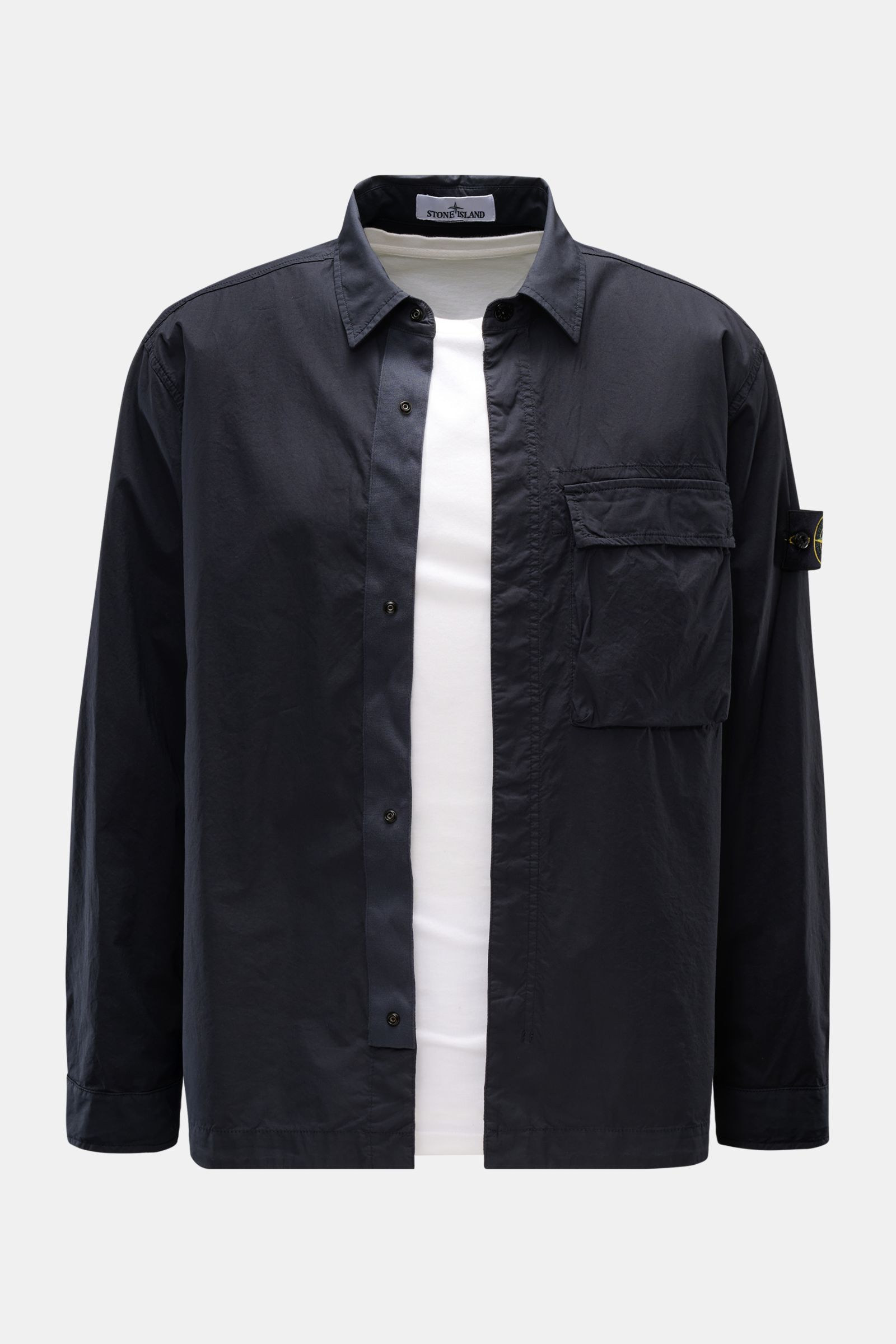 Front view of a Stone Island Overshirt navy in slim fit, made of elastic cotton with soft touch, featuring a concealed snap button placket, turn-down collar, chest patch pocket, compass badge on the upper arm, and buttoned sleeve cuffs. Vielseitiges Essen