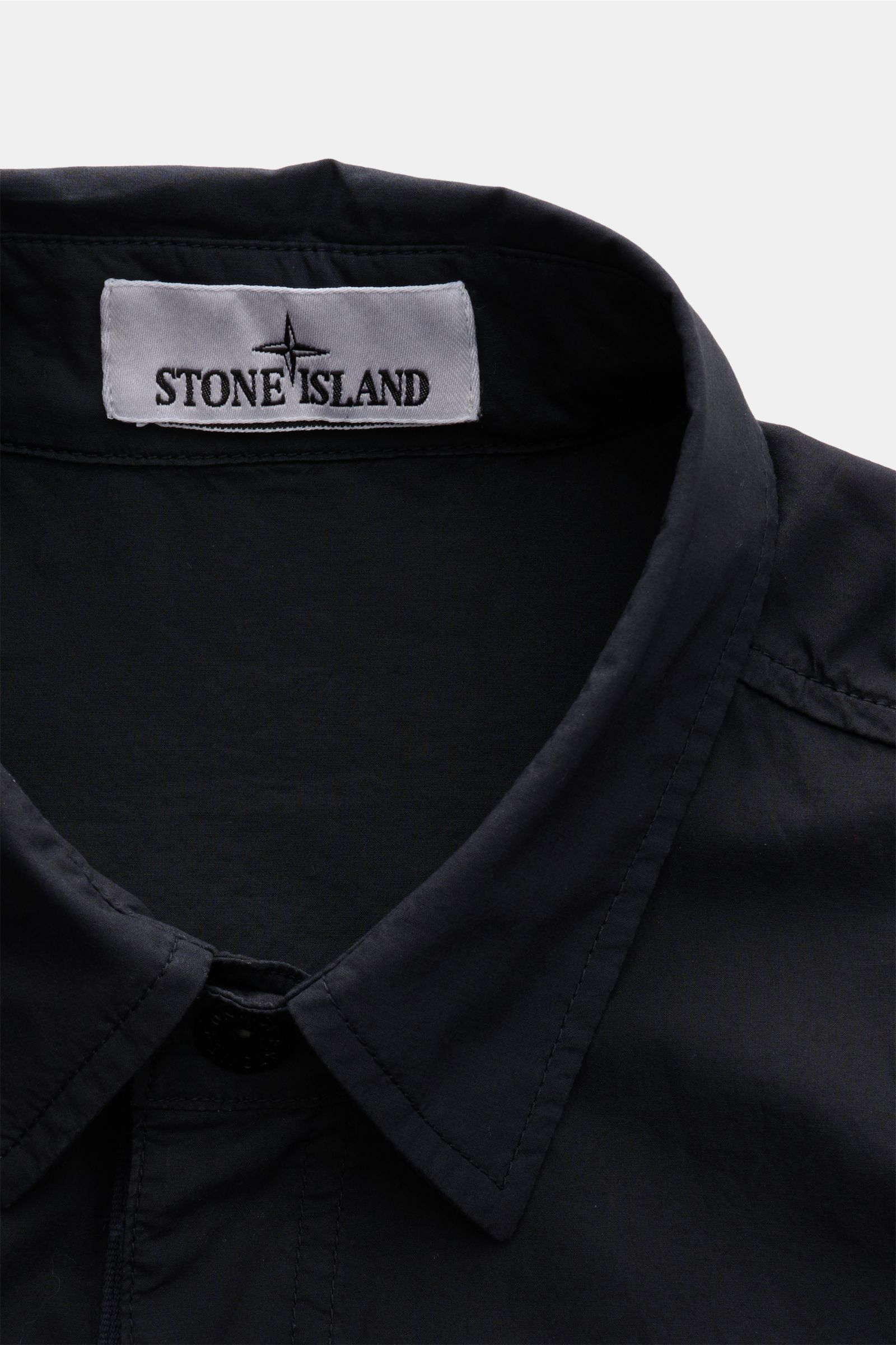 Close-up front top view of Stone Island Overshirt navy collar and label, vielseitiges Essential: Mit seinem zeitlosen Design wird das STONE ISLAND Overshirt in der Frühlingssaison zum legeren Layering-Piece. elastische Baumwolle, weicher Griff, Slim Fit, 