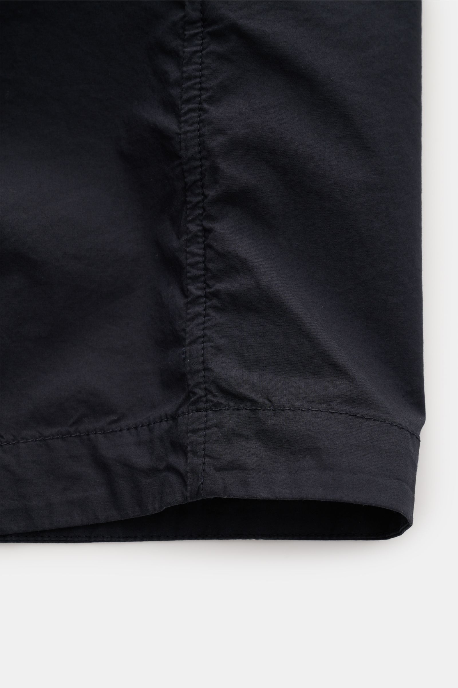 Close-up view of the hem and side seam of the Stone Island Overshirt navy, showcasing elastic cotton fabric with a soft touch.

Vielseitiges Essential: Mit seinem zeitlosen Design wird das STONE ISLAND Overshirt in der Frühlingssaison zum legeren Layer
