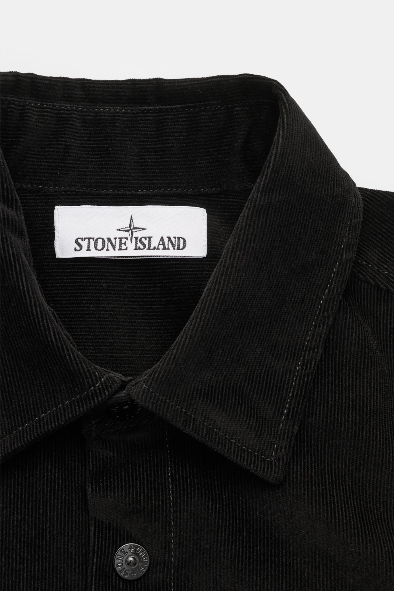 Close-up front view of the Stone Island Corduroy overshirt black showing the turn-down collar, snap button placket, and fabric texture.

Sporty and practical – this straight cut overshirt by STONE ISLAND is characterised by iconic style and pure cotton
