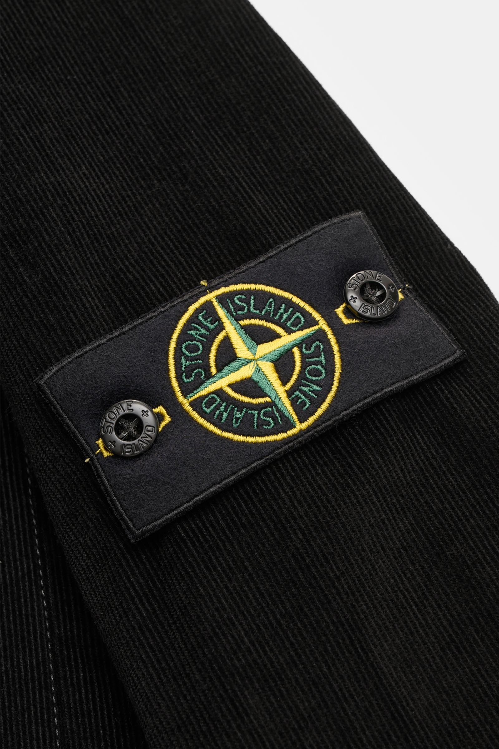 Close-up view of the Stone Island Corduroy overshirt black showing the signature compass badge on the sleeve.

Sporty and practical – this straight cut overshirt by STONE ISLAND is characterised by iconic style and pure cotton corduroy. The signature c