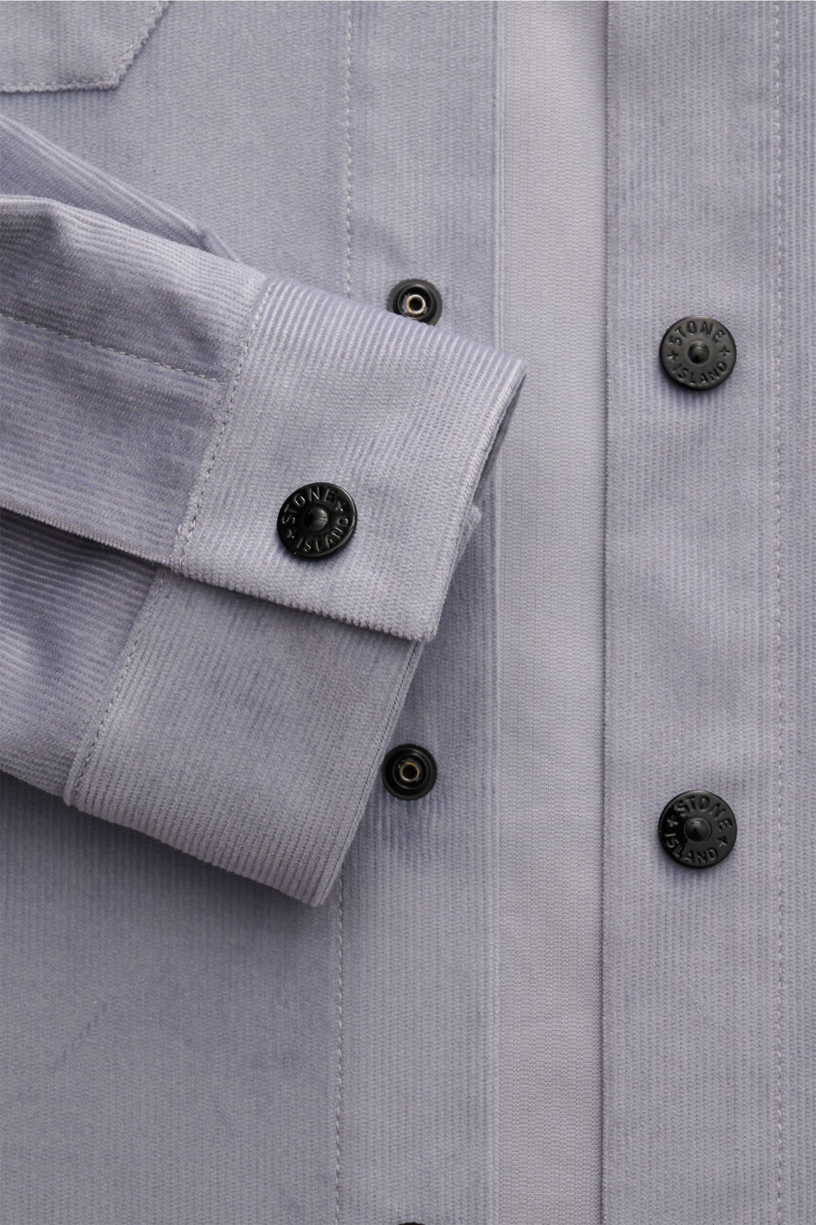 Stone Island Cord Overshirt rauchblau, Nahaufnahme von Manschette und Druckknopfleiste aus reiner Bio-Baumwolle, slim fit, Kompass-Badge.