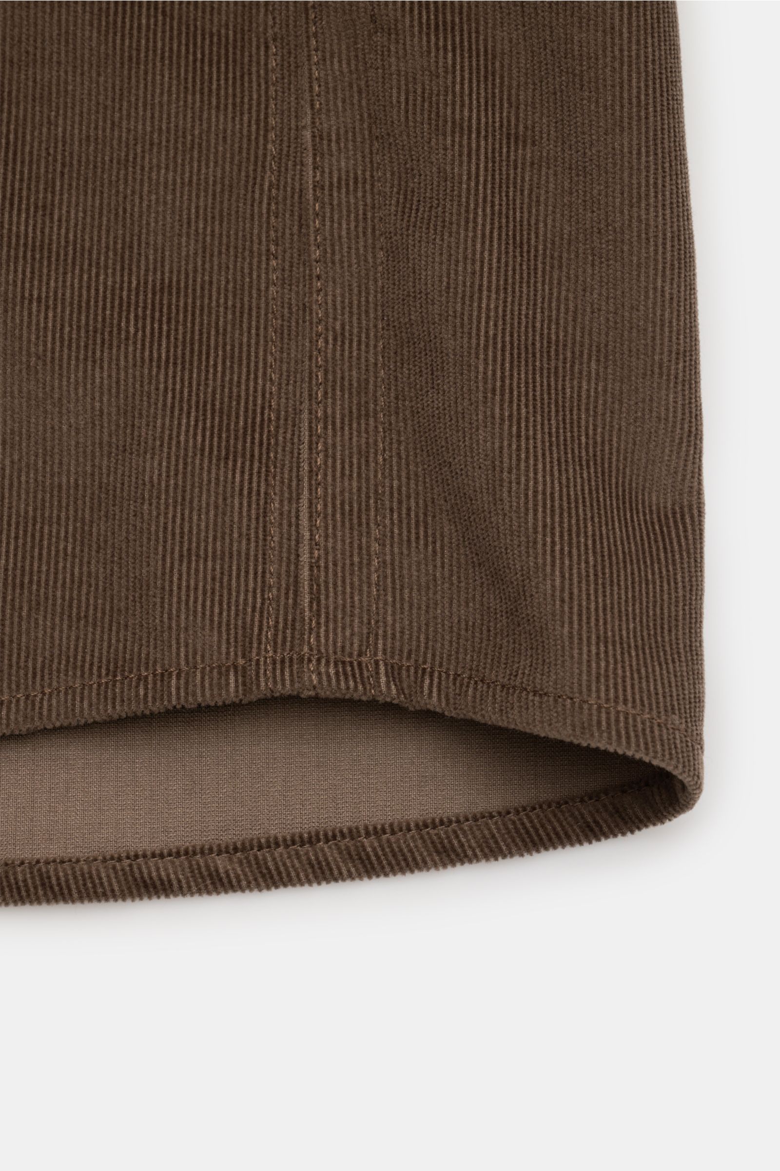 Close-up front view of the hem of the Stone Island Corduroy overshirt brown, showing fine corduroy texture and stitching.

Description:  
Sporty and practical – this straight cut overshirt by STONE ISLAND is characterised by iconic style and pure cotto
