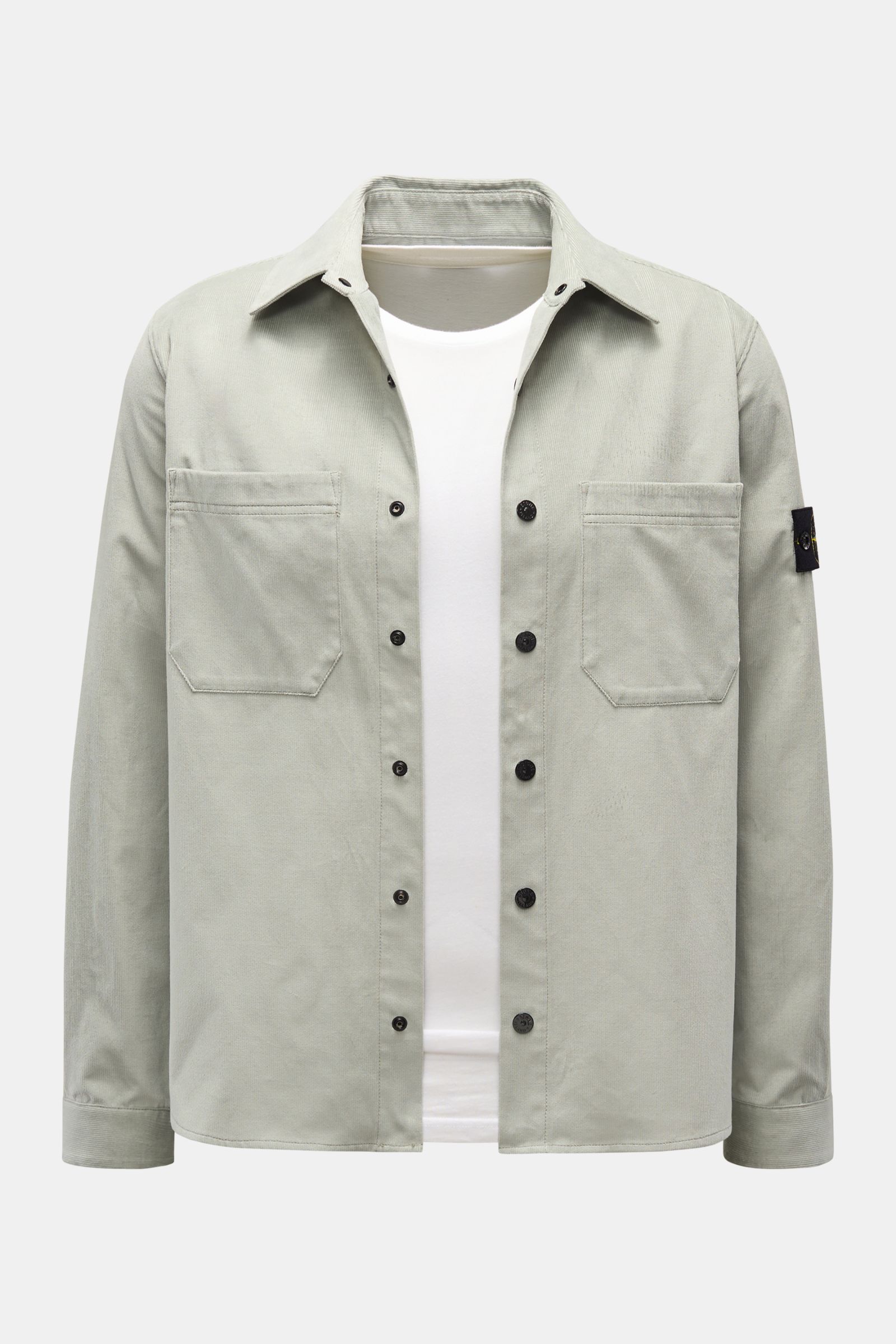 Stone Island Cord Overshirt salbei, vorne fotografiert, gerade geschnitten, aus weichem Bio-Baumwoll-Cord mit Umlegekragen, Brusttaschen, Manschetten und Kompass-Badge am Ärmel.