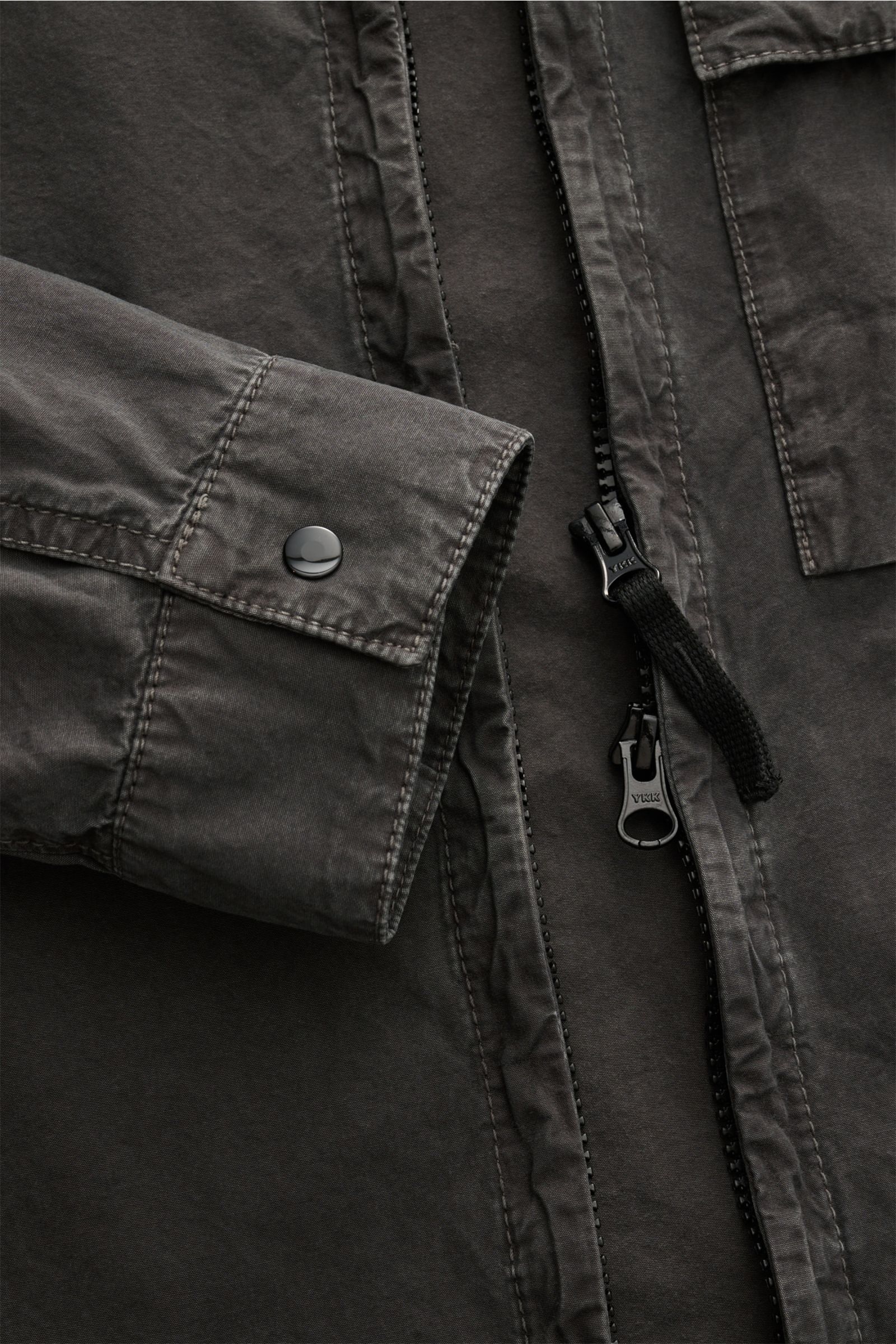 Close-up front view of Stone Island Overshirt 'Brushed Canvas' dunkelgrau in soft pure cotton with slim fit, two-way zipper, buttoned cuffs, chest pocket, and compass badge.