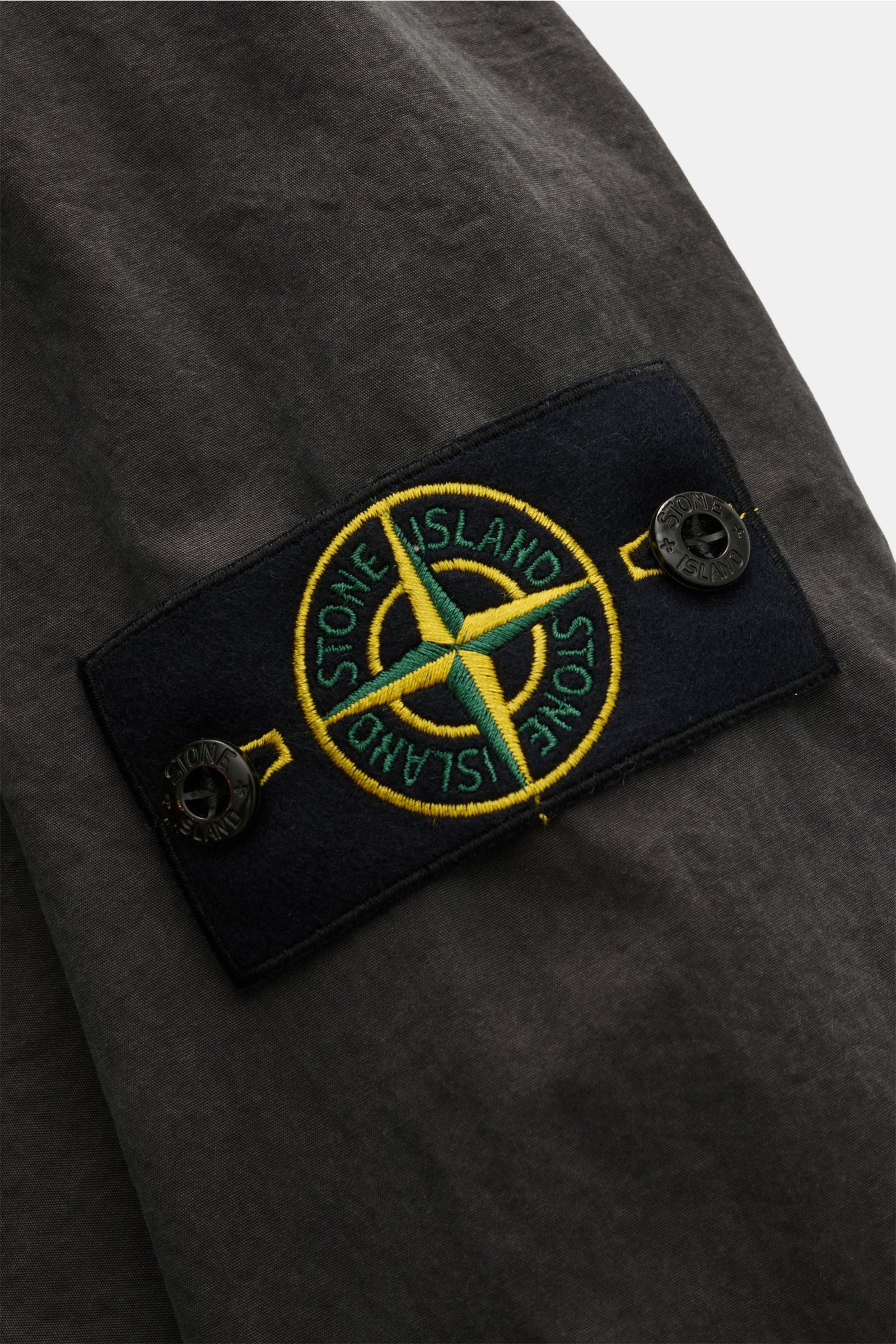 Close-up of the compass badge on the sleeve of Stone Island Overshirt 'Brushed Canvas' dunkelgrau, showing the dark gray brushed cotton fabric. Lässiges Layering-Piece: Das Canvas-Overshirt von STONE ISLAND lässt sich mühelos zu legeren Looks kombinieren.