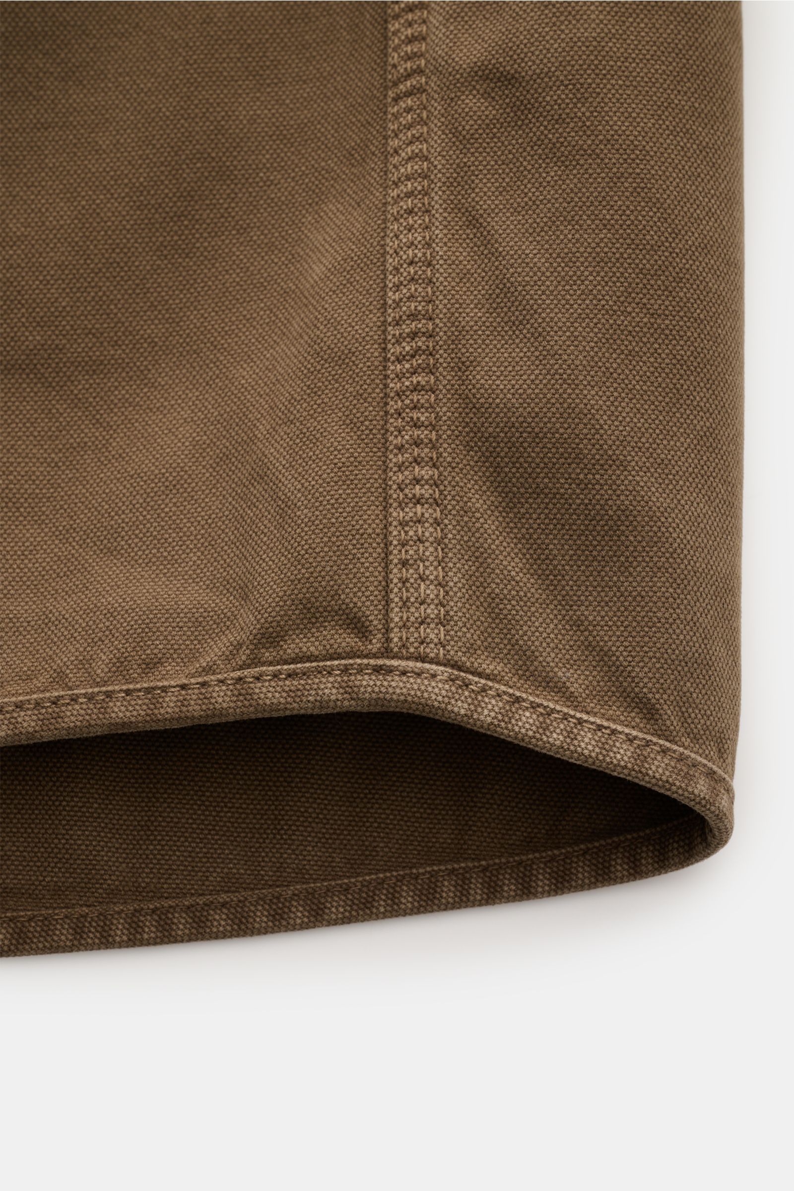 Close-up detail of the hem and side seam of the Stone Island Overshirt 'Panama' khaki, showing the textured pure cotton fabric and sturdy stitching from a side angle. Vielseitiges Layering-Piece: Das zeitlose Overshirt von STONE ISLAND überzeugt mit seine