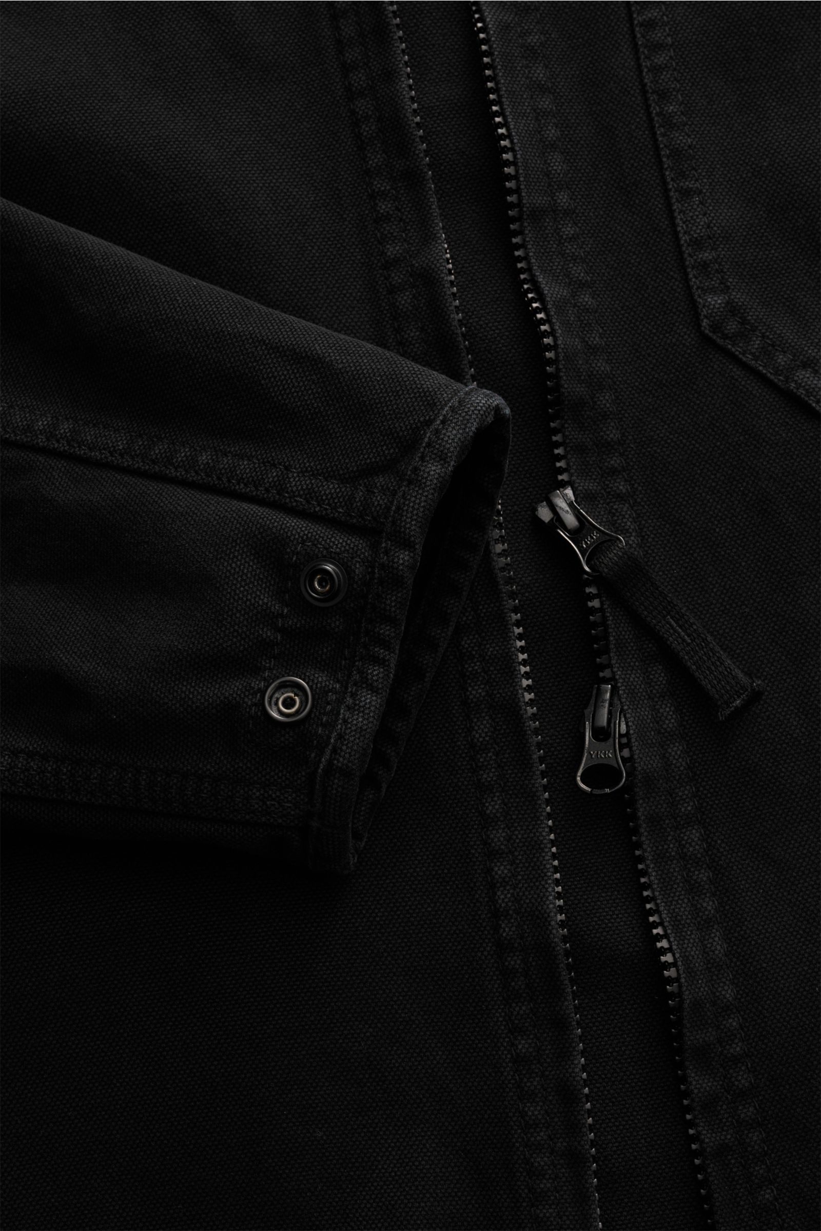 Nahaufnahme des Stone Island Overshirt 'Panama' schwarz, zeigt den robusten Zwei-Wege-Reißverschluss und Ärmelabschluss mit Knöpfen aus reiner Baumwolle.