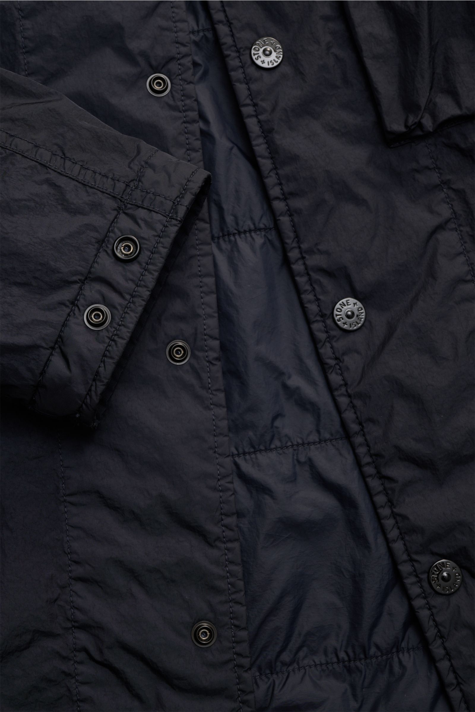 Nahaufnahme aus schräger Perspektive des Stone Island Overshirts 'Crinkle Reps' navy aus wind- und wasserabweisender Microfaser mit Druckknopfleiste.