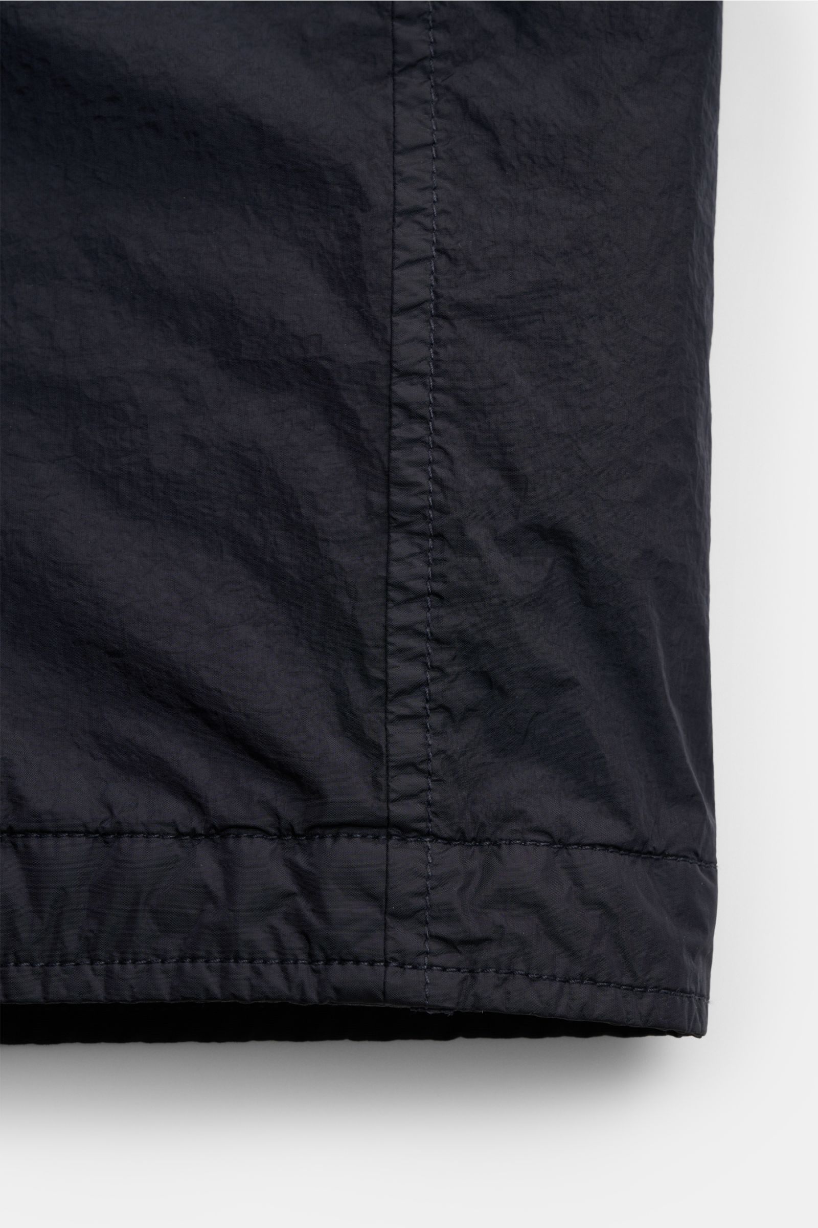 Nahaufnahme des unteren Bereichs vom Stone Island Overshirt 'Crinkle Reps' navy, Slim Fit, wind- und wasserabweisende Microfaser, garment dyed, mit feiner Naht und geschmeidigem Futterstoff.