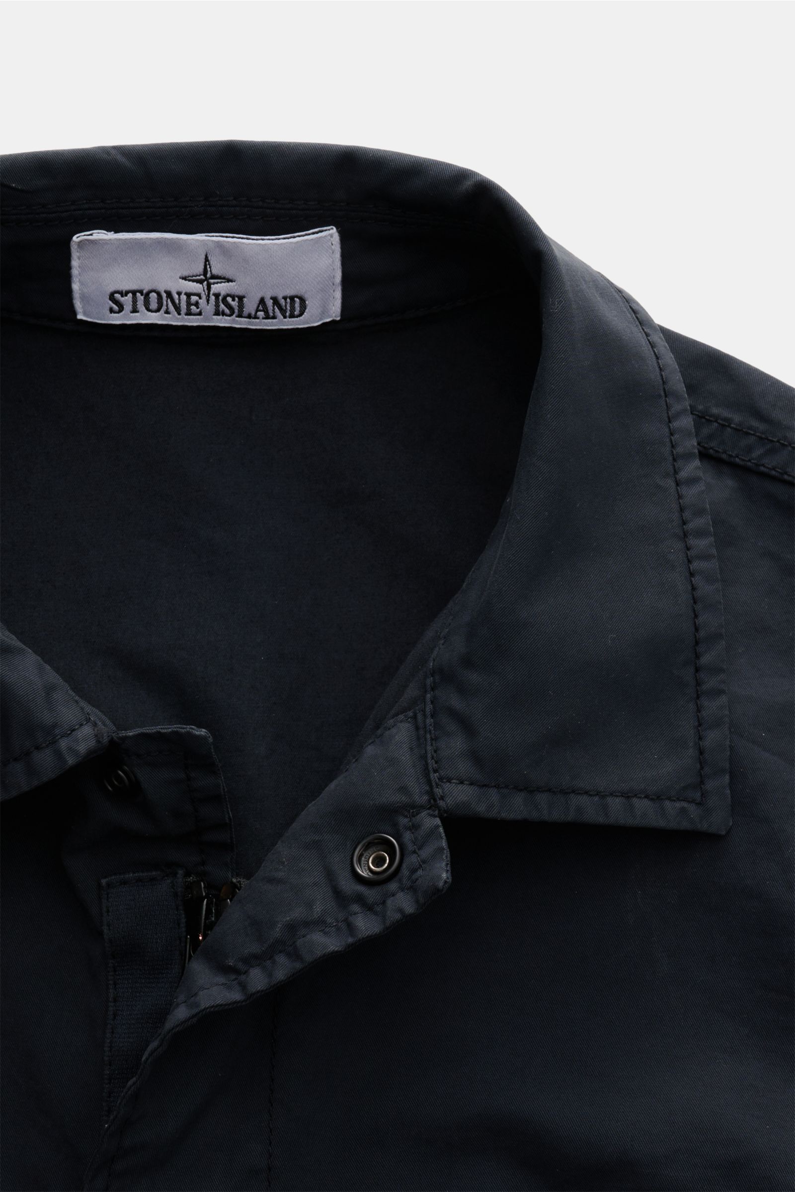 Stone Island Overshirt 'Stretch Cotton' navy shown from a close-up front angle, featuring elastic cotton, soft touch, slim fit, two-way zipper with snap buttons, turn-down collar, chest pocket with buttoned flap, signature compass badge on sleeve, and adj