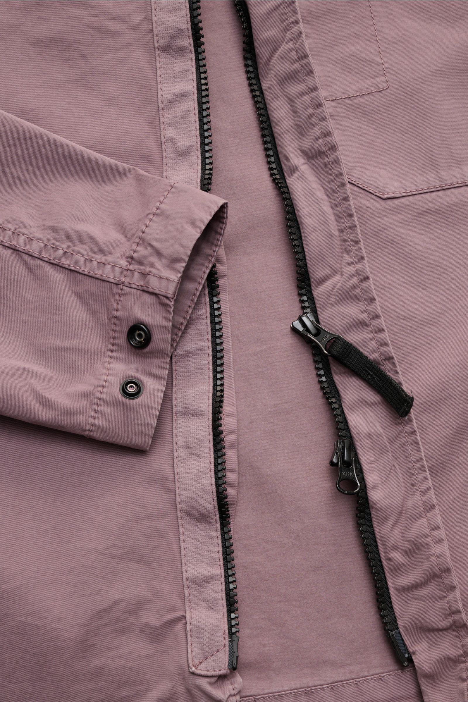 Close-up front view of Stone Island Overshirt 'Stretch Cotton' flieder in lilac, featuring two-way zipper, snap buttons, and cotton fabric.

Sportives Overshirt mit urbaner Lässigkeit: Dieser markante Hybrid aus Casual Hemd und Jacke von STONE ISLAND i