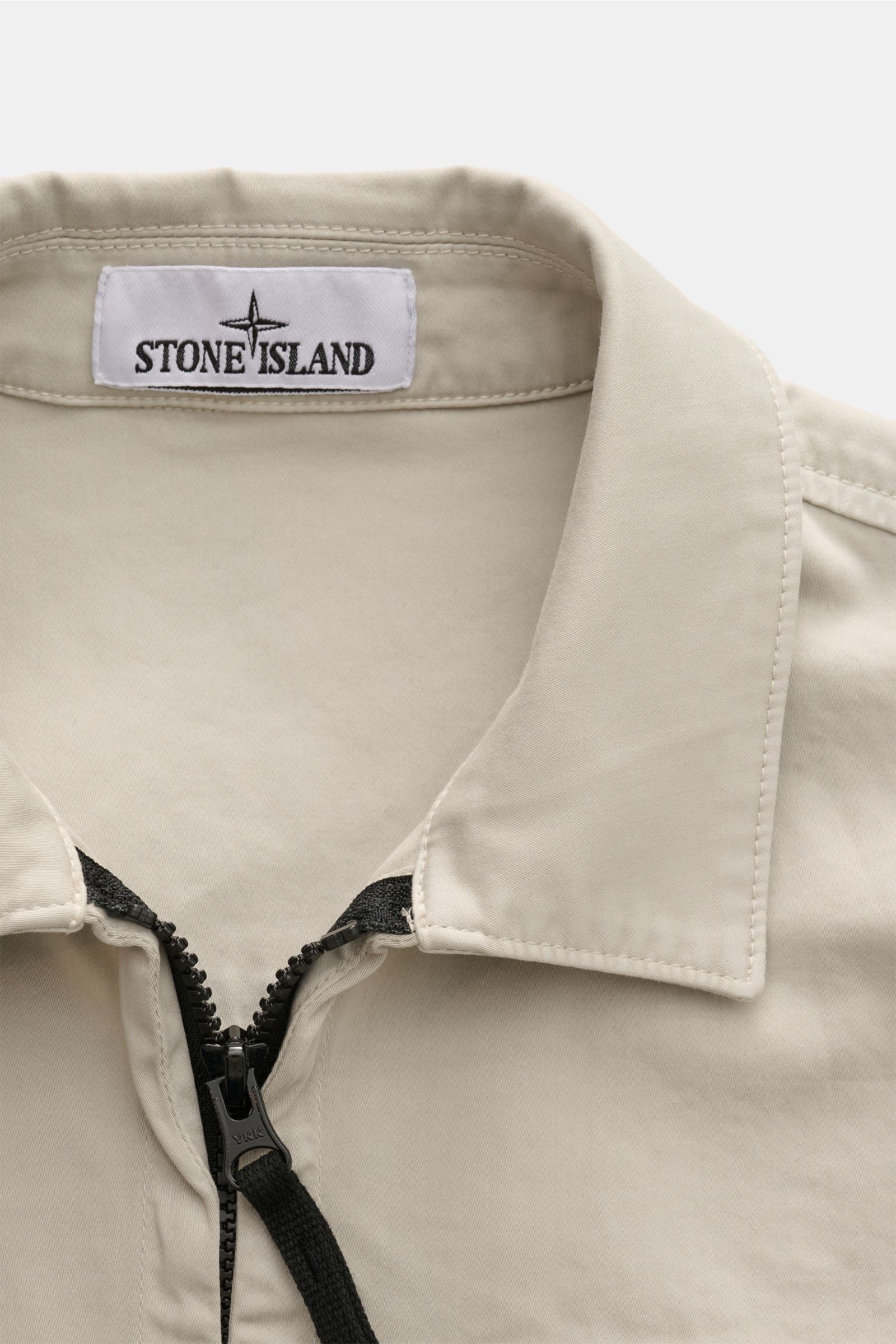 Stone Island Overshirt 'Cotton Satin' sand, Detailaufnahme von oben auf den Umlegekragen mit Zwei-Wege-Reißverschluss, elastische Baumwolle, Slim Fit, weicher Griff.