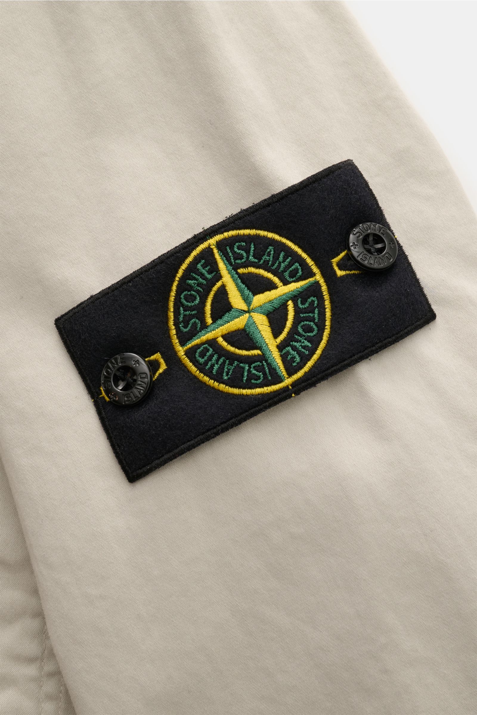 Stone Island Overshirt 'Cotton Satin' sand, Detailansicht des Kompass-Badges am Oberarm aus elastischer Baumwolle mit weichem Griff.