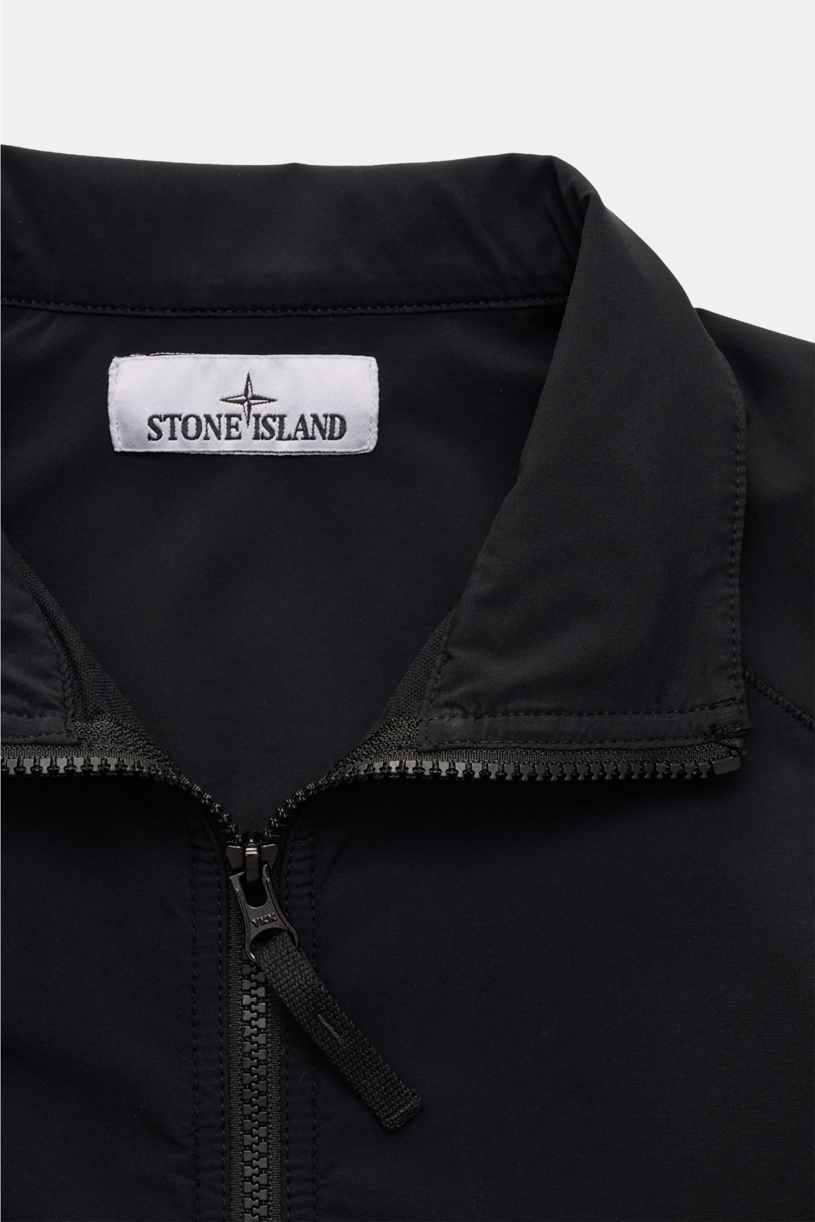 Close-up front view of the Stone Island Overshirt 'Nylon Stretch' black showing the standing collar, robust two-way zip, and Stone Island label inside. Function and comfort by STONE ISLAND: The overshirt 'Nylon Stretch' is made of stretchy microfibre whic