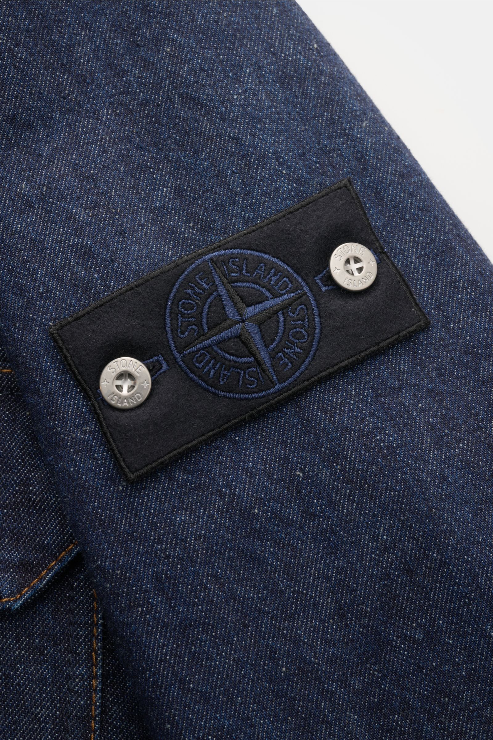 Stone Island Denim overshirt navy close-up from the sleeve showing the compass badge on indigo-dyed cotton denim fabric. For casual denim looks: Made from indigo-dyed cotton yarn, this overshirt from the STONE ISLAND 'Denim' Capsule Collection features di