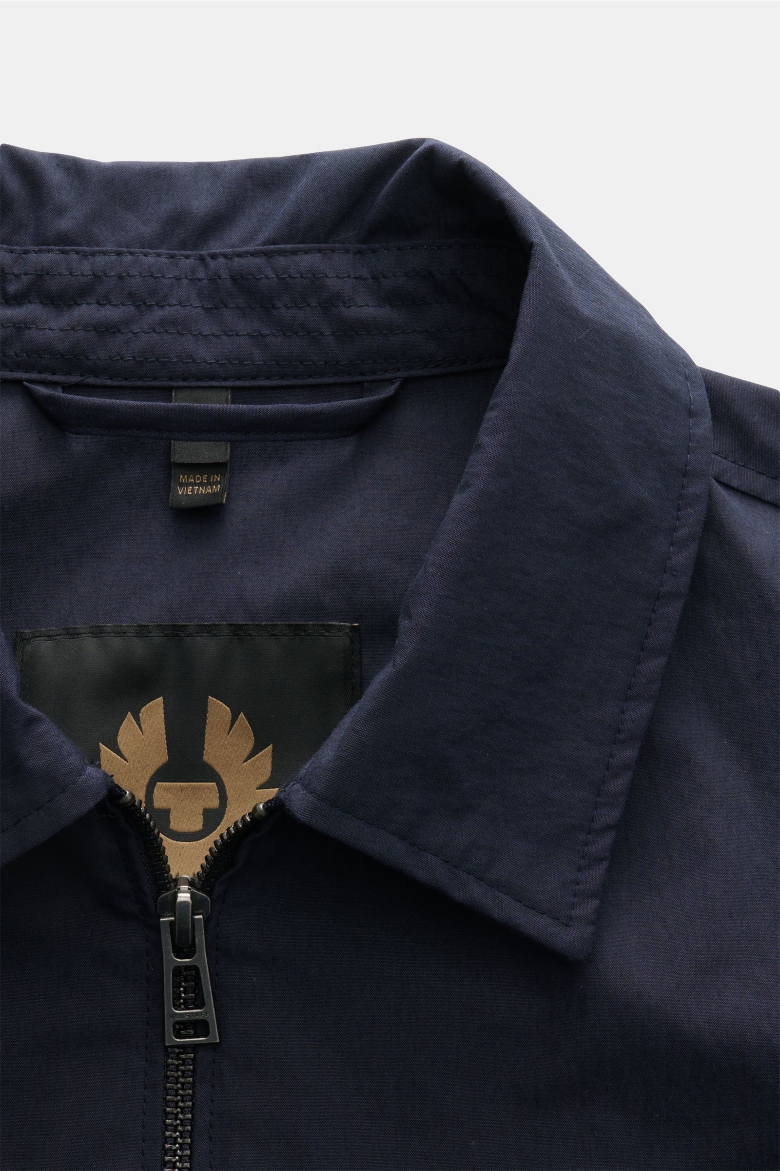 Nahaufnahme des Kragens vom Belstaff Overshirt 'Cargo' navy aus Baumwoll-Microfaser-Mix mit Umlegekragen und Zwei-Wege-Reißverschluss, seitlich oben fotografiert.