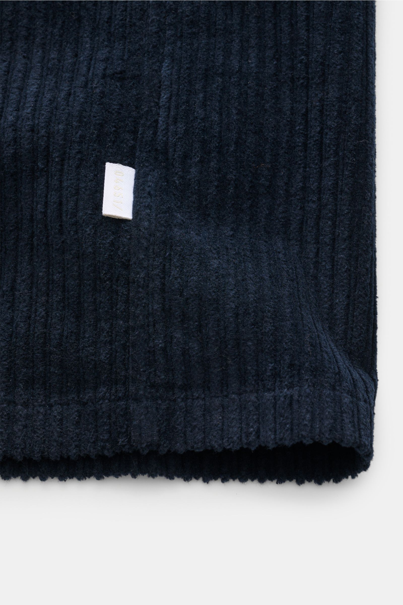 Close-up front view of the hem of the 04651/ A trip in a bag Cord-Overshirt navy showing Breitcord aus Baumwolle, komfortabler Stretch-Anteil, weicher Griff, garment dyed, oversized, Druckknopfleiste, Kent-Kragen, aufgesetzte Brusttaschen in Kontraststoff