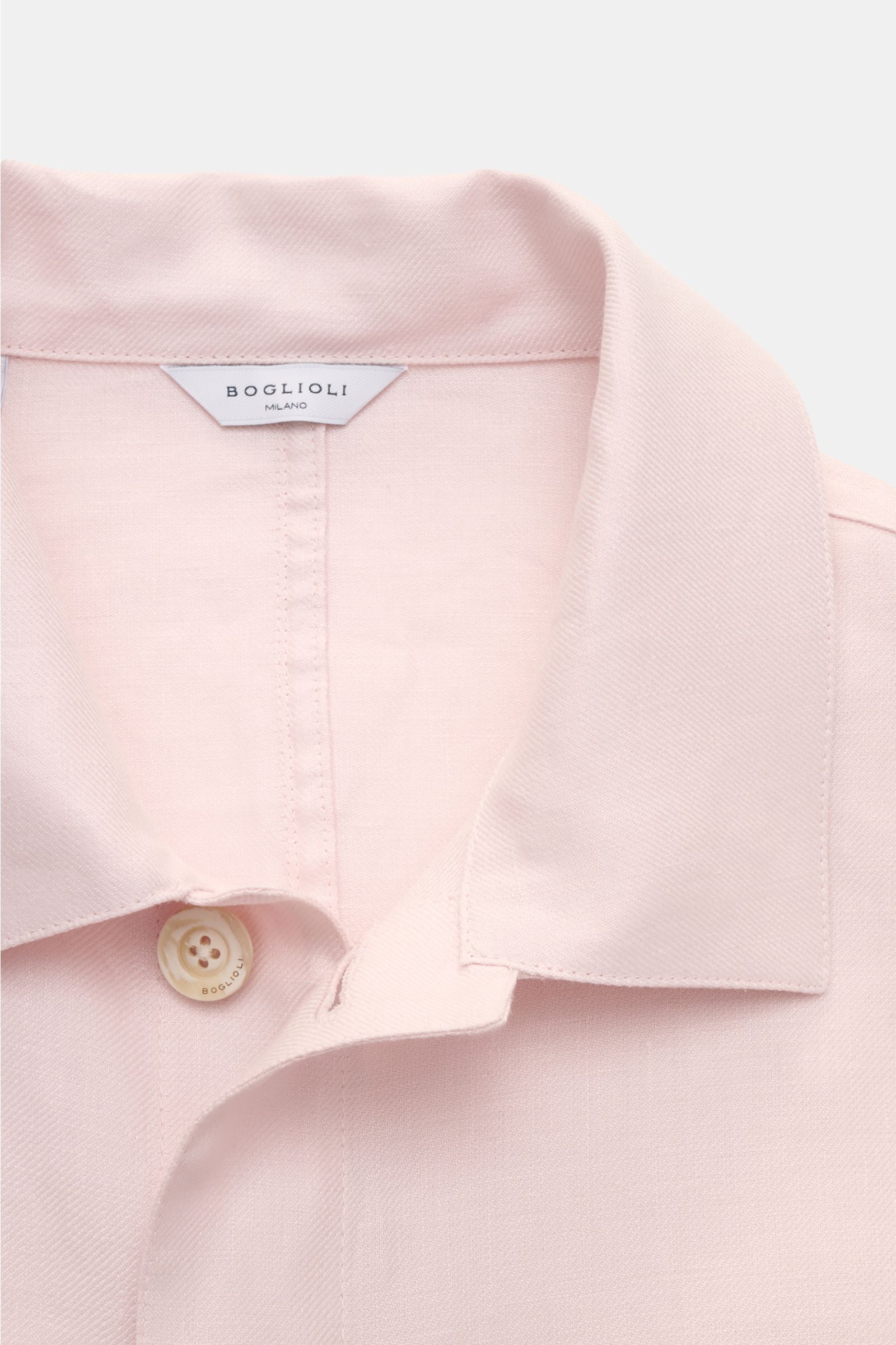 Close-up front view of the Boglioli Leinen Overshirt rosé, showcasing the soft pink linen fabric, fine twill texture, unconstructed design, pointed collar, and branded button. Ideal für edle Layering-Looks in der Übergangszeit: Mit dem unkomplizierten Unc