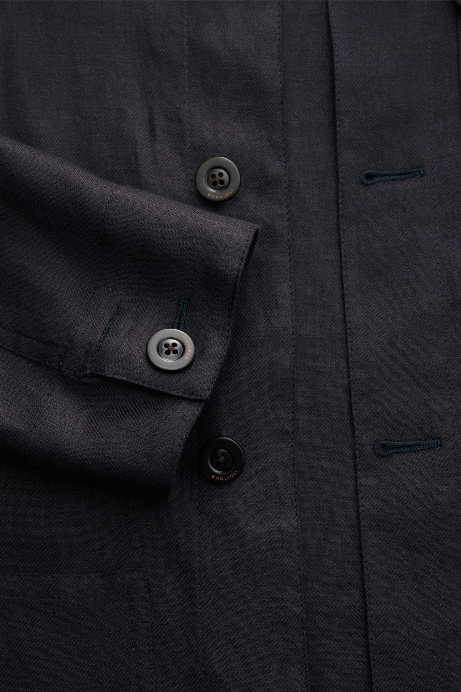 Nahaufnahme des Boglioli Leinen Overshirt navy aus feinem Twill, Slim Fit mit Umlegekragen, Fünf-Knopf-Leiste, Manschette mit Knopf, Brust- und Hüfttaschen, Unconstructed Design, fotografiert von oben.