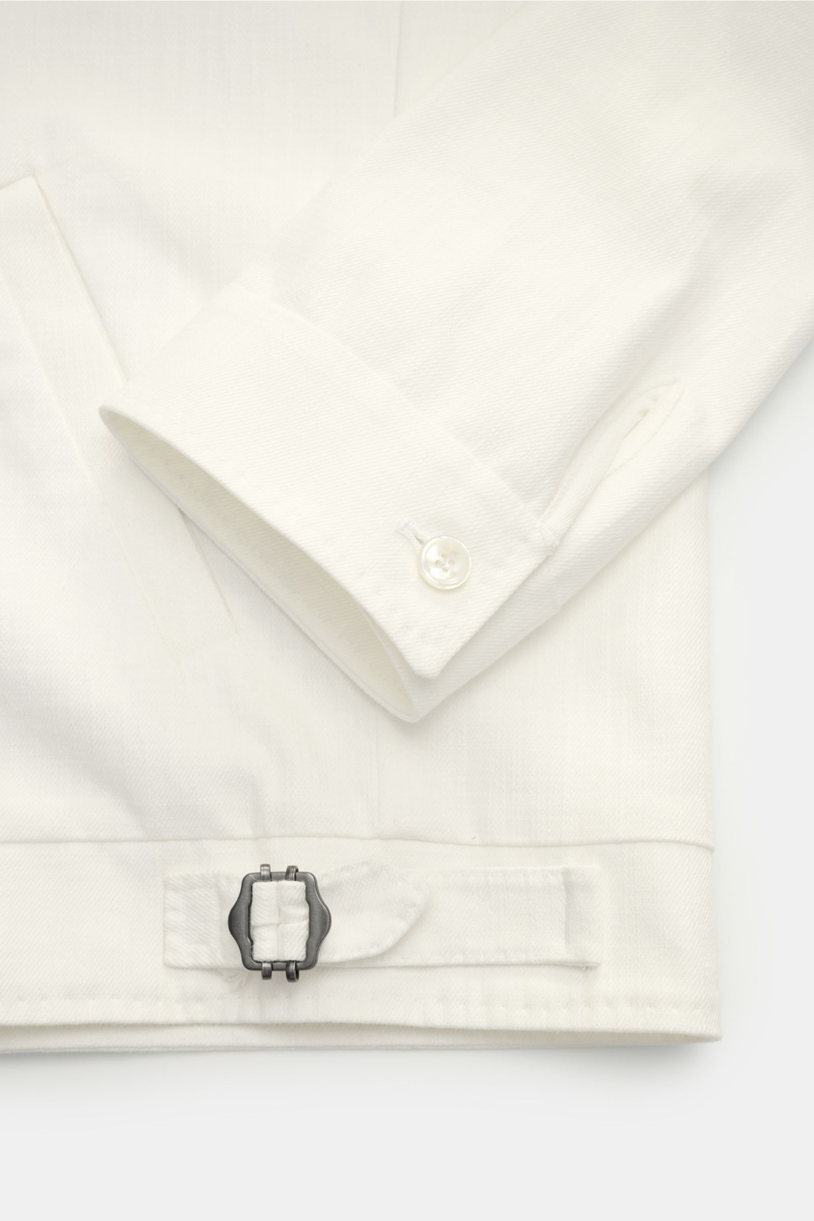 Close-up front view of the sleeve cuff and adjustable waist buckle on the Stile Latino Overshirt 'Gbu Teseo' cream, showcasing pure cotton fabric and soft feel.

Luxurious layers: This sophisticated overshirt by STILE LATINO combines exquisite quality 
