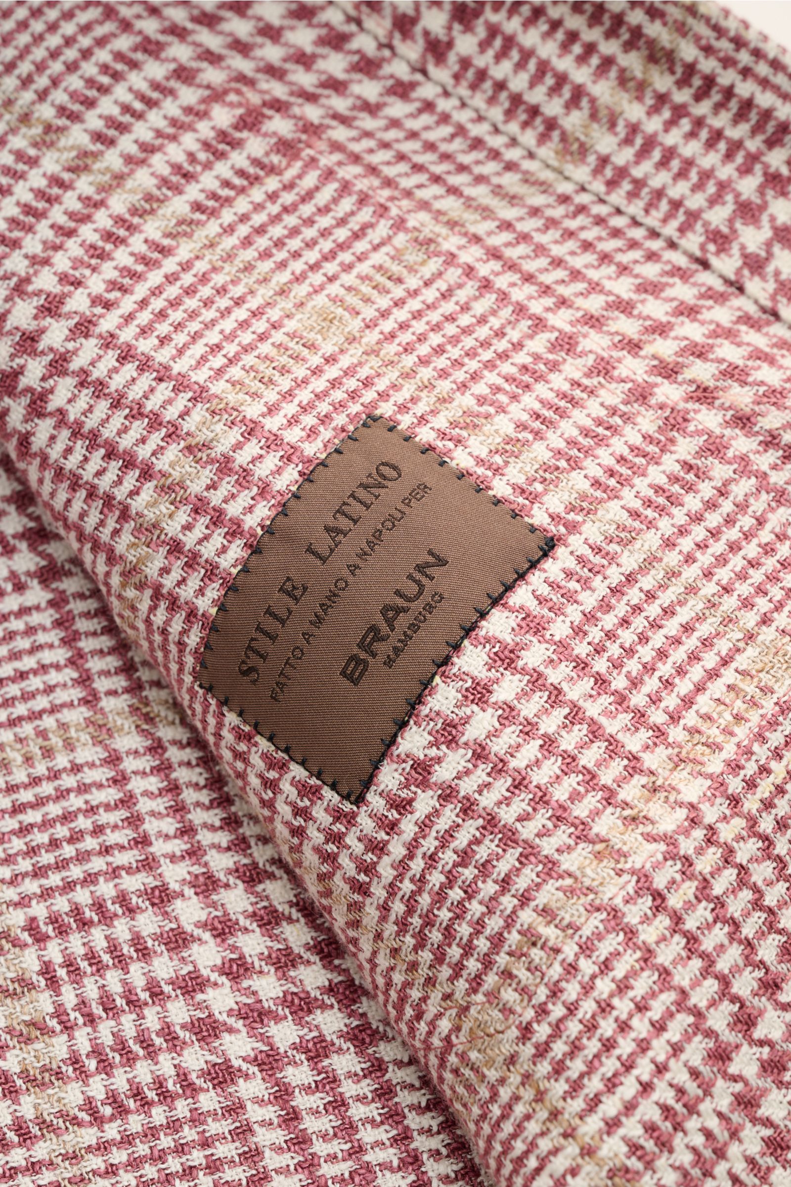 Close-up angled view of Stile Latino Overshirt 'Gu Kansas' dark red/cream checked glen check fabric with a brown stitched label.

Luxuriously confident style from Italy: This elegant overshirt by STILE LATINO combines exquisite quality with timelessly 