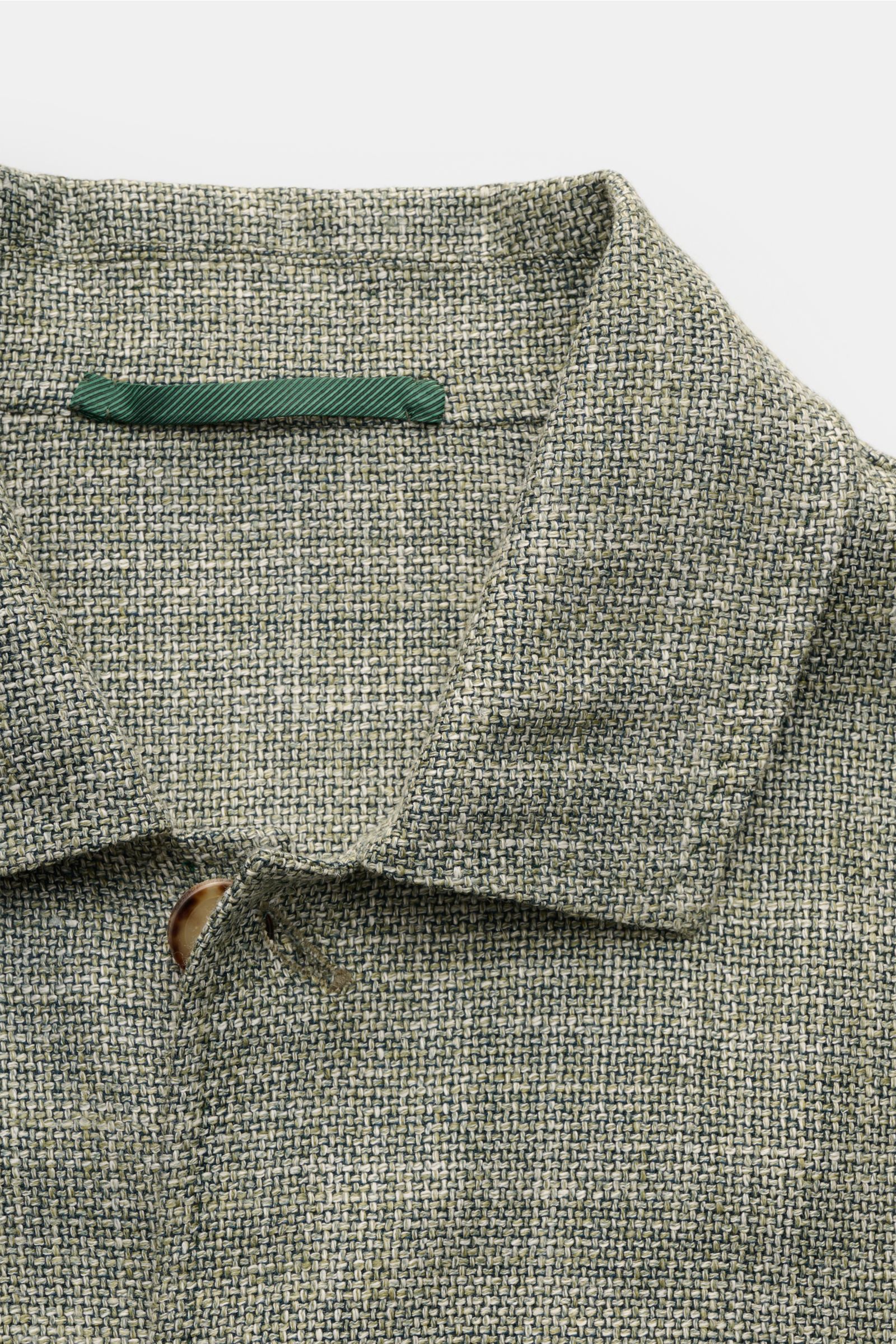 Close-up front view of the Stile Latino Overshirt 'Gu Texas' dark green/off-white mottled, showcasing its wool, silk and linen blend fabric, five-button placket, and turn-down collar.  
Luxurious layers: This sophisticated overshirt by STILE LATINO com