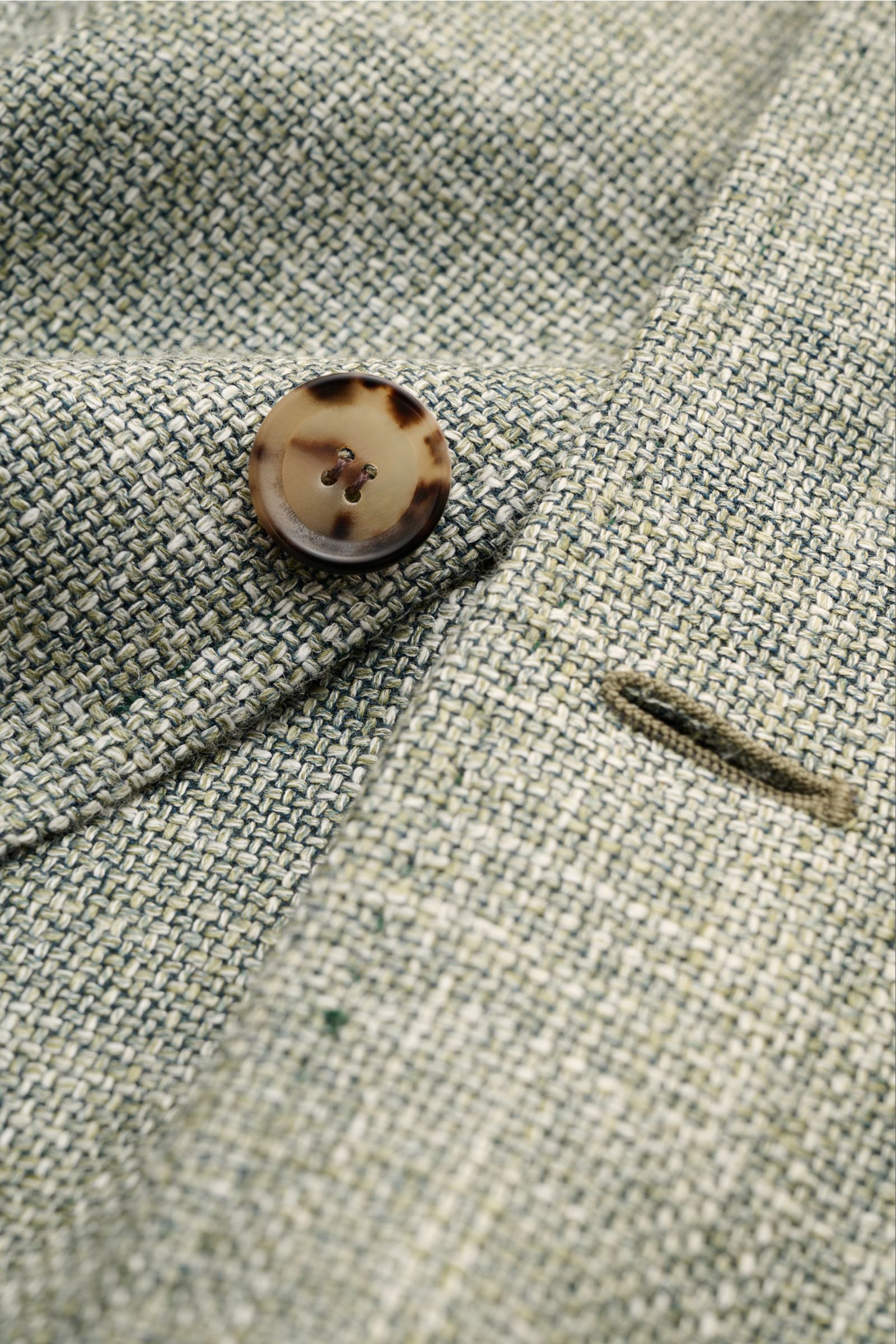 Close-up of Stile Latino Overshirt 'Gu Texas' dark green/off-white mottled fabric showing a brown button and buttonhole, front detail.

Luxurious layers: This sophisticated overshirt by STILE LATINO combines exquisite quality with timeless elegance – a