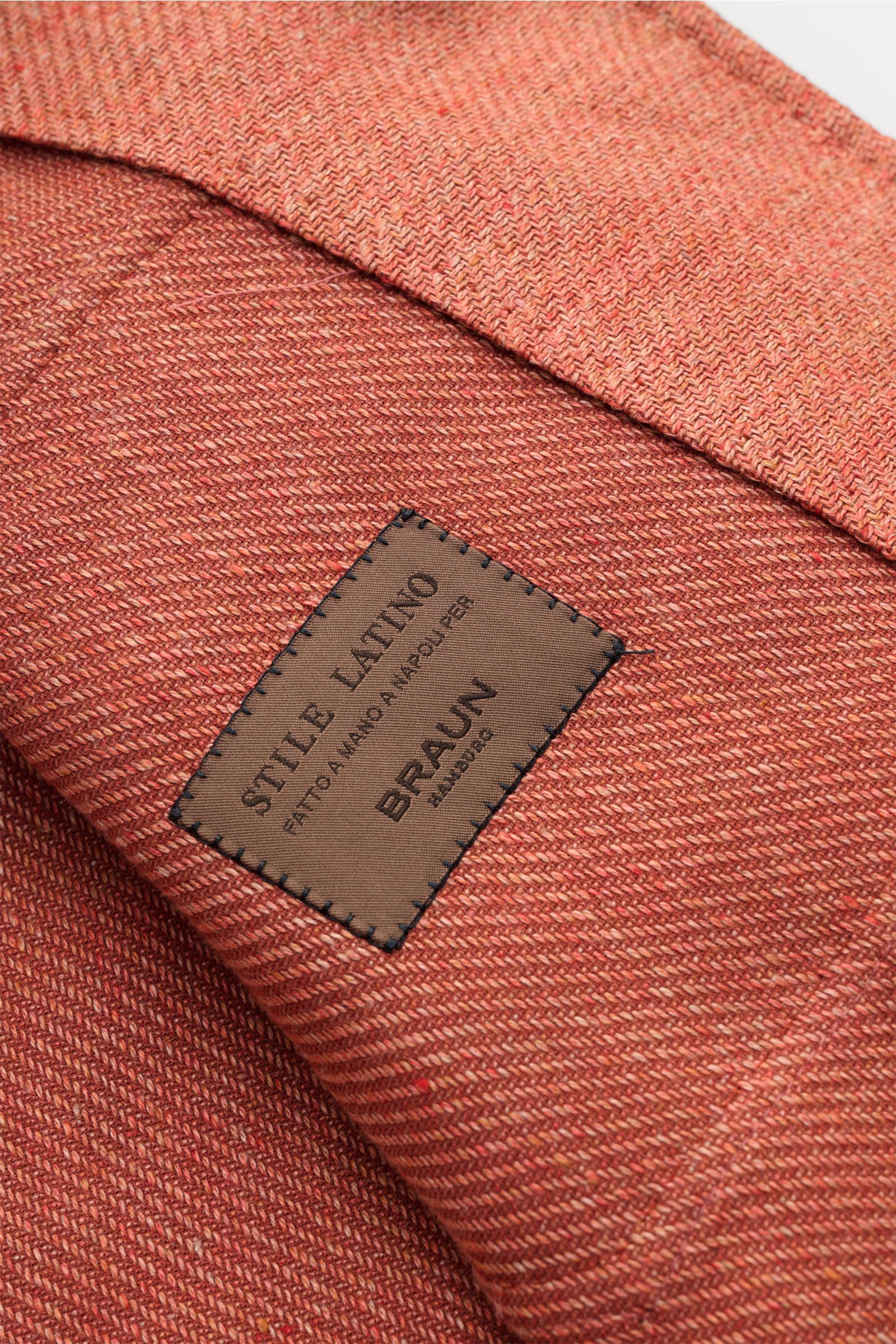 Close-up, angled view of the textured fabric and label on the Stile Latino Overshirt 'Gu Texas' orange mottled, highlighting the linen and cotton blend. Luxurious layers: This sophisticated overshirt by STILE LATINO combines exquisite quality with timeles