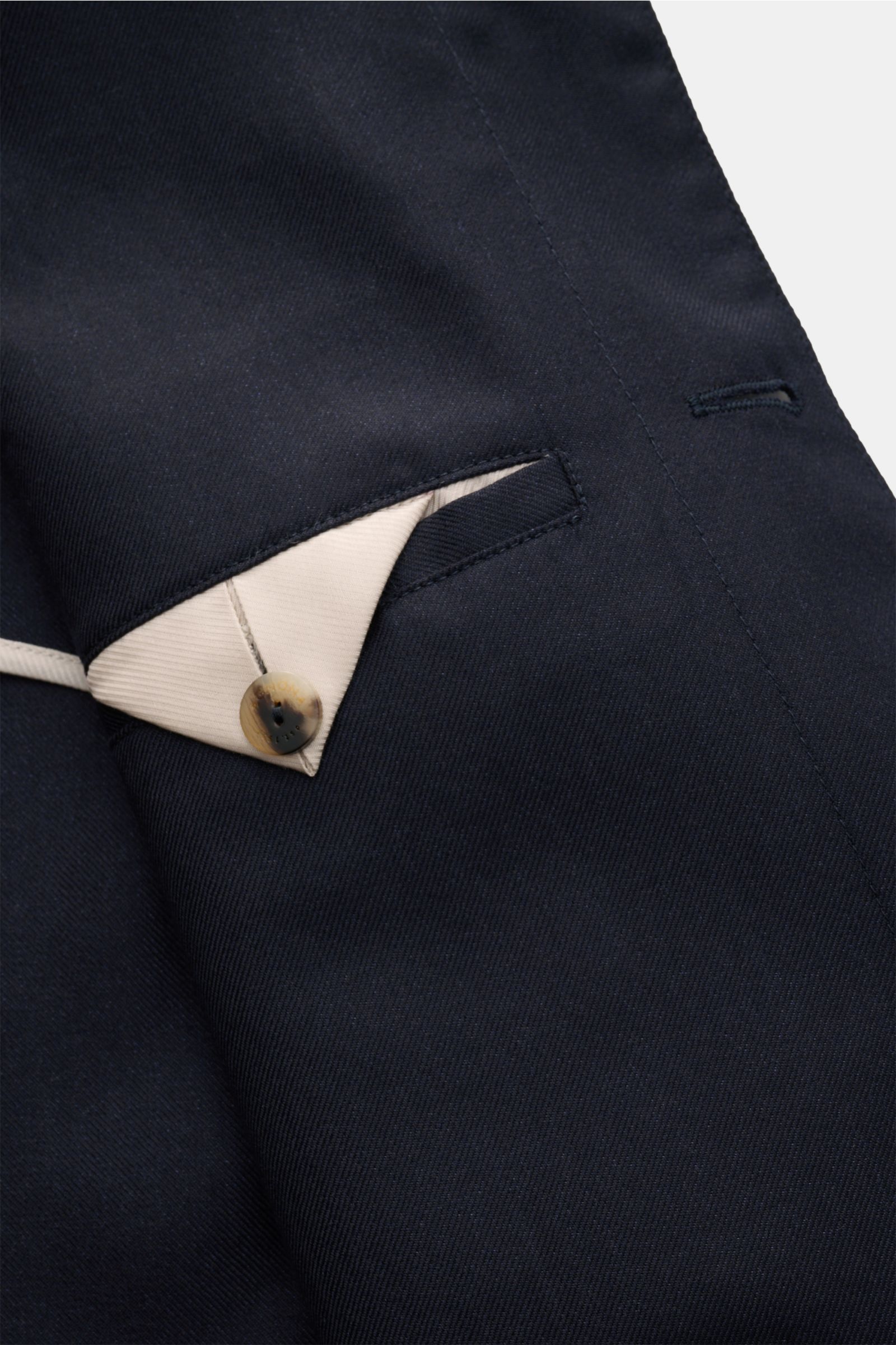 Close-up image from above of the navy Agnona Overshirt showing a beige inner pocket flap with button, highlighting the luxurious cashmere-silk mix fabric. Stilvolles Layering-Piece in Perfektion: Mit seinem luxuriösen Cashmere-Seide-Mix wird das edle O