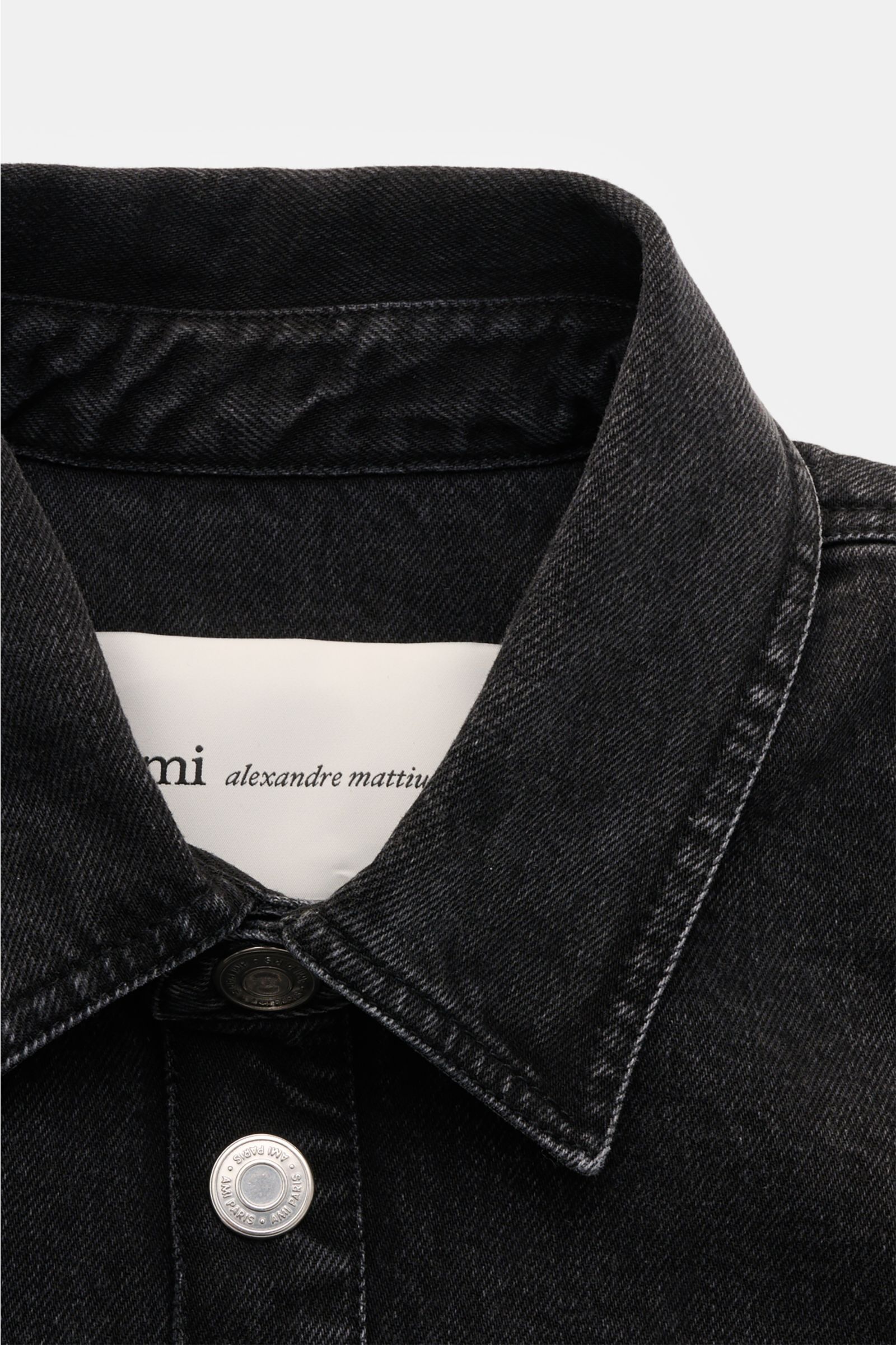 Nahaufnahme von Ami Paris Jeans-Overshirt dunkelgrau aus Baumwoll-Denim, Oversized Fit, Umlegekragen, Logo-Stitching und Knopfleiste.