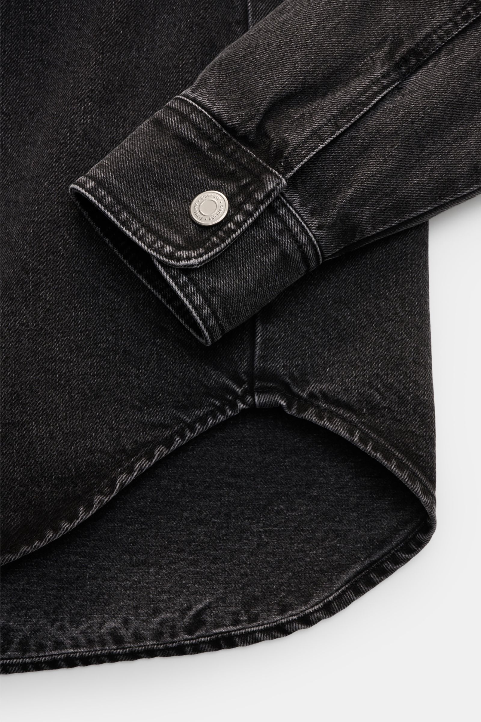 Ami Paris Jeans-Overshirt dunkelgrau aus reiner Baumwolle mit Oversized Fit, gerundetem Saum, Sportmanschette und Druckknopf, Detailansicht von unten.
