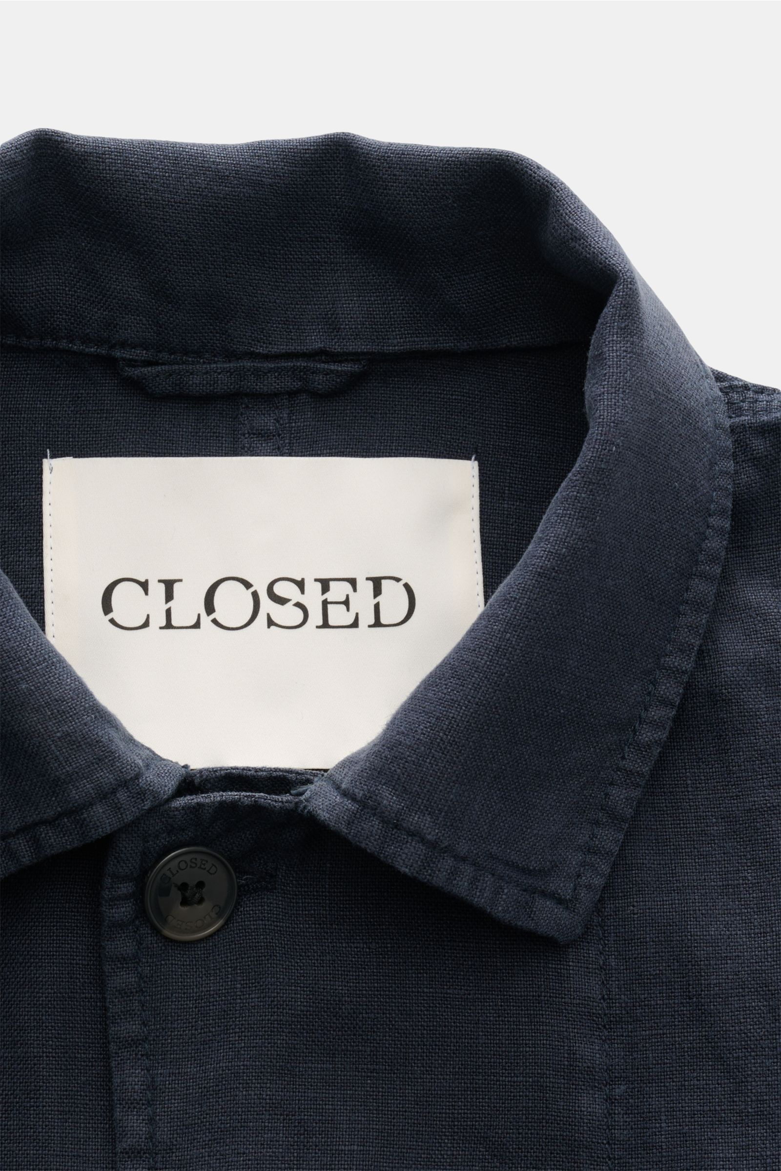 Nahaufnahme von Umlegekragen und oberem Knopf des Closed Overshirt 'Cargo Jacket' navy aus reinem Leinen mit weichem Griff, Regular Fit, fotografiert von oben.