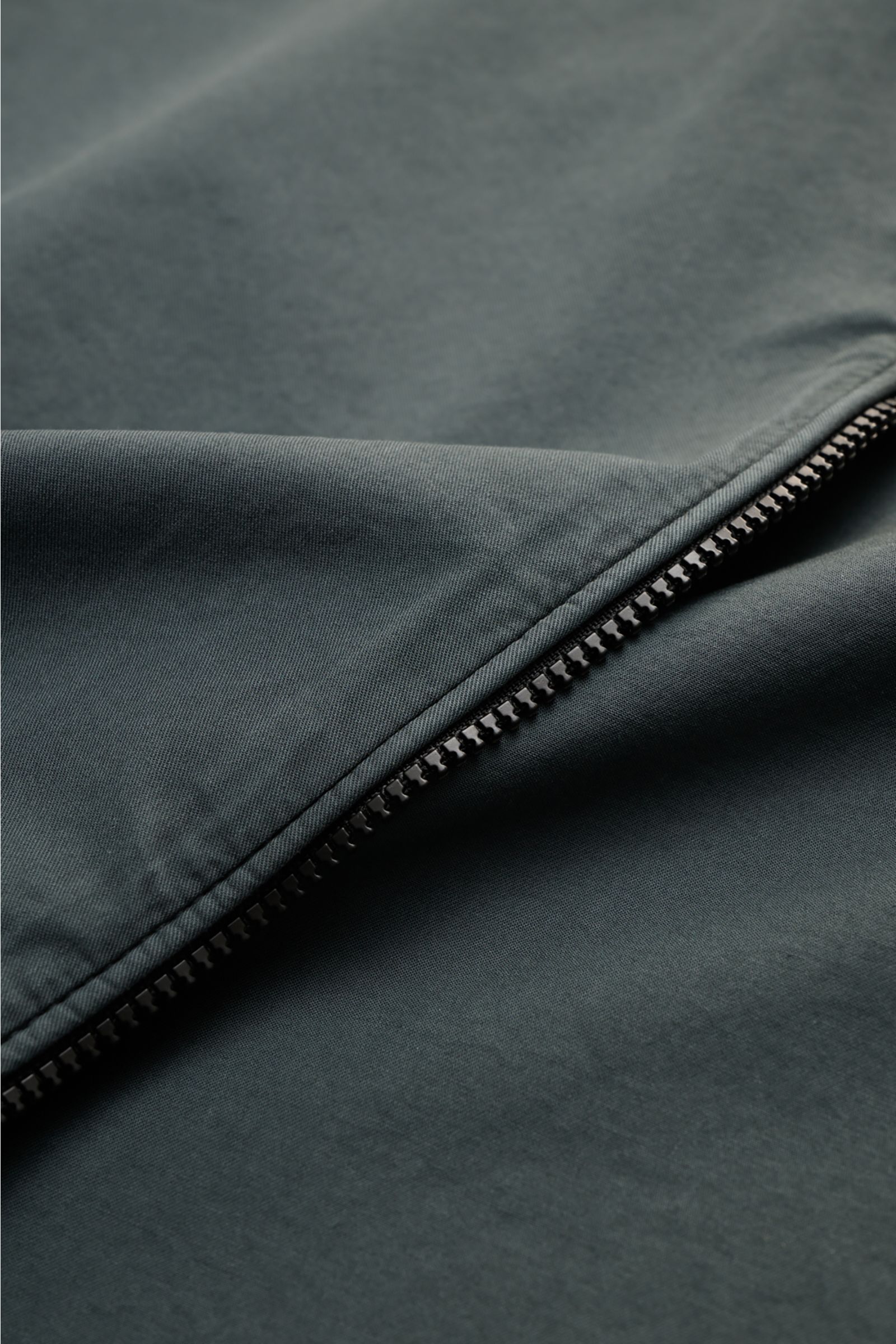 Close-up of the two-way zipper on the C.P. Company Overshirt dunkelgrau, showing fine cotton fabric from a top-down perspective. Lässiges Layering-Piece: Das Overshirt von C.P. COMPANY ist der ideale Begleiter für urbane Frühlingslooks. Reine Baumwolle, l