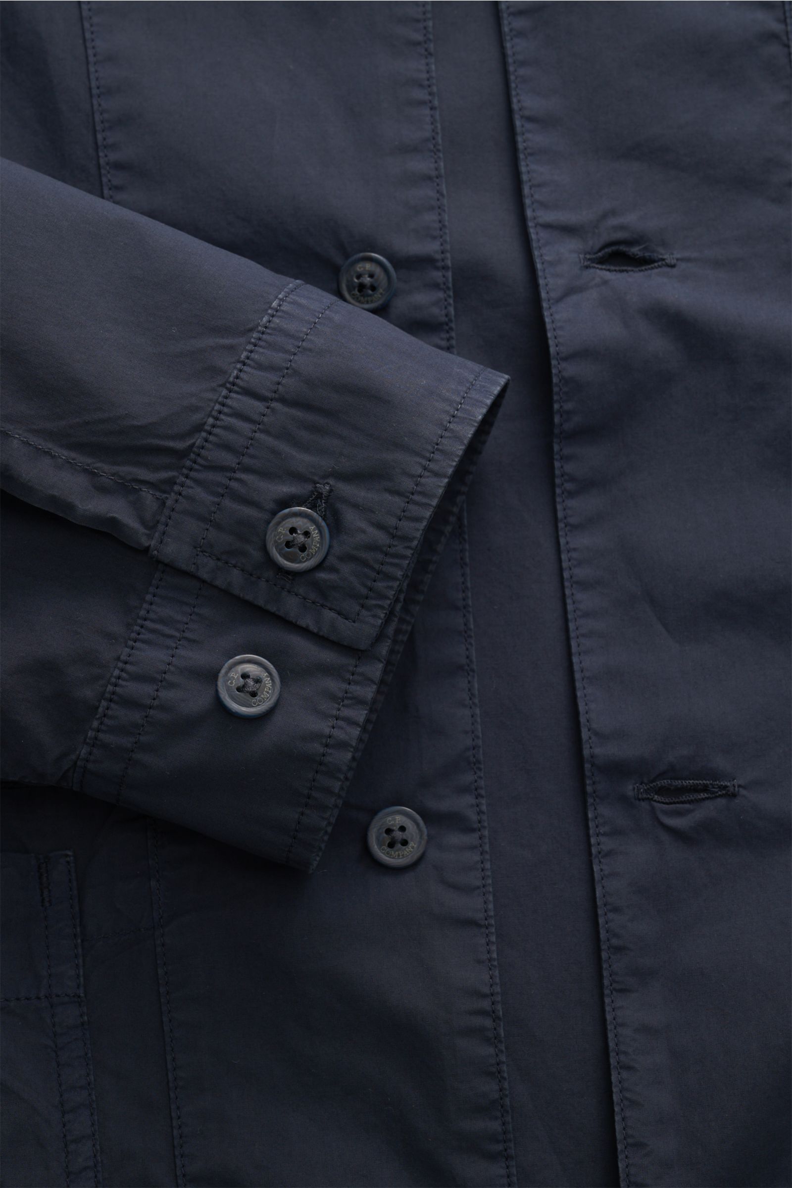Nahaufnahme des C.P. Company Overshirt navy in Slim Fit, reine Baumwolle, leichte Qualität, zeigt Ärmel mit Manschette und Sechs-Knopf-Leiste.
