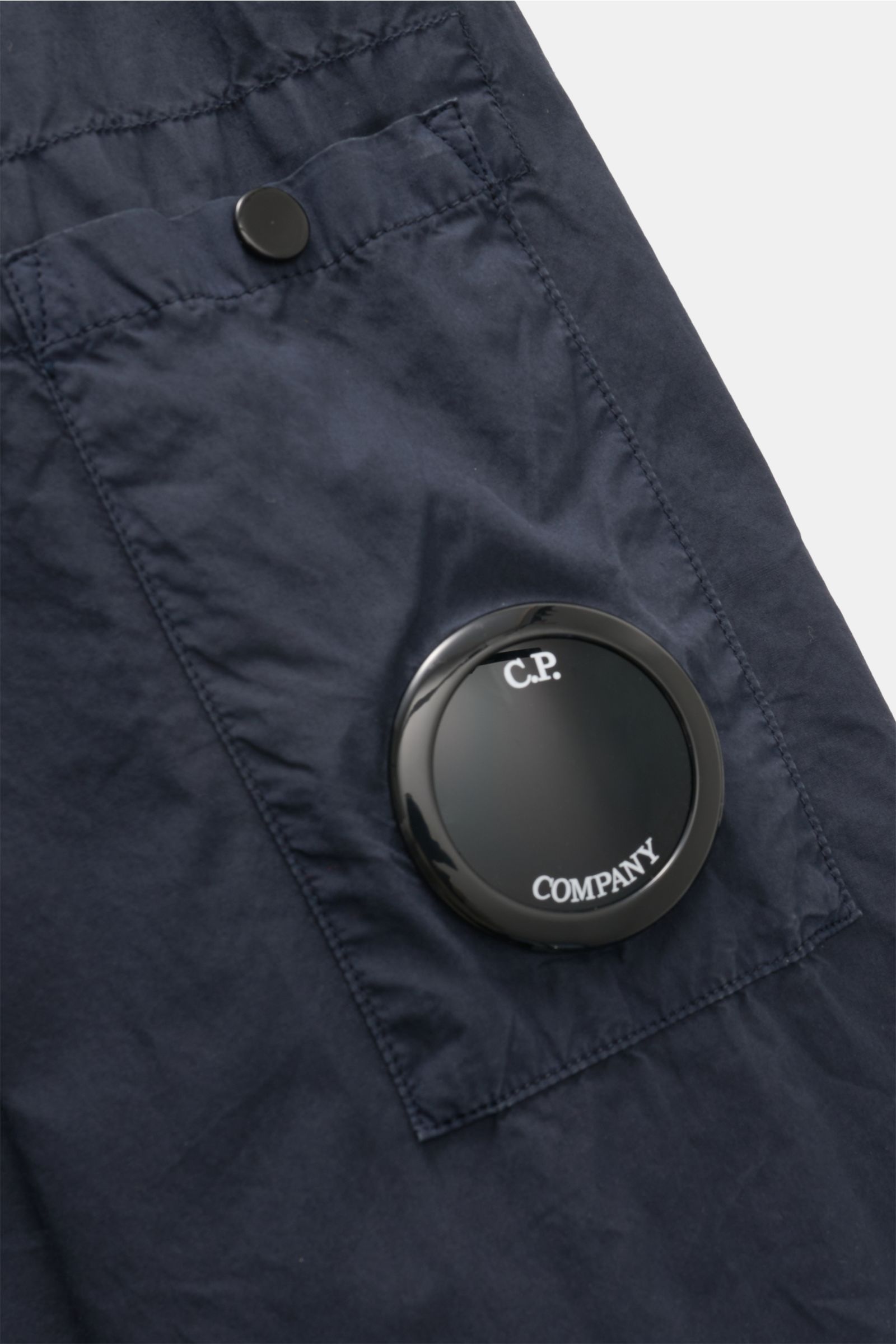 Nahaufnahme des C.P. Company Overshirt navy in Slim Fit, reine Baumwolle, mit Manschette, Fronttasche und Logodetail am Ärmel.