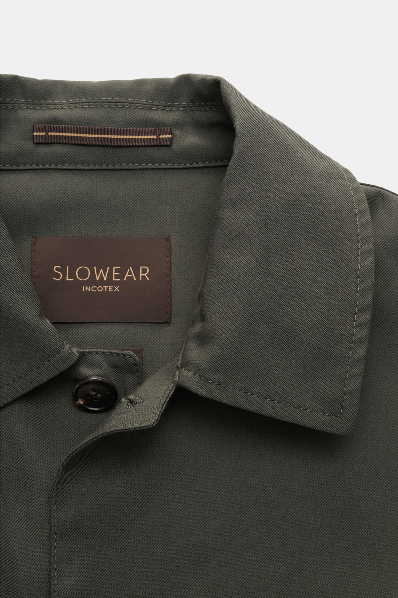Close-up front view of the Incotex Overshirt olive showcasing the turn-down collar, horn button, and branded label inside. Workwear charm meets modern urban ease: This unlined overshirt in pure cotton twill by INCOTEX features practical flap pockets on th