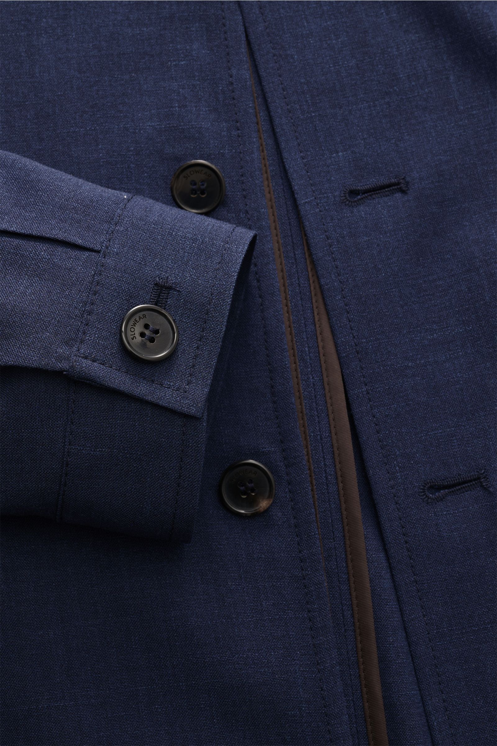 Nahaufnahme des Incotex Overshirts navy meliert im Blouson-Look, zeigt Schurwoll-Seide-Mix, Knopfmanschette, sechs-Knopf-Leiste, paspelierte Fronttaschen und elastischen Saum, fotografiert aus seitlicher Perspektive.