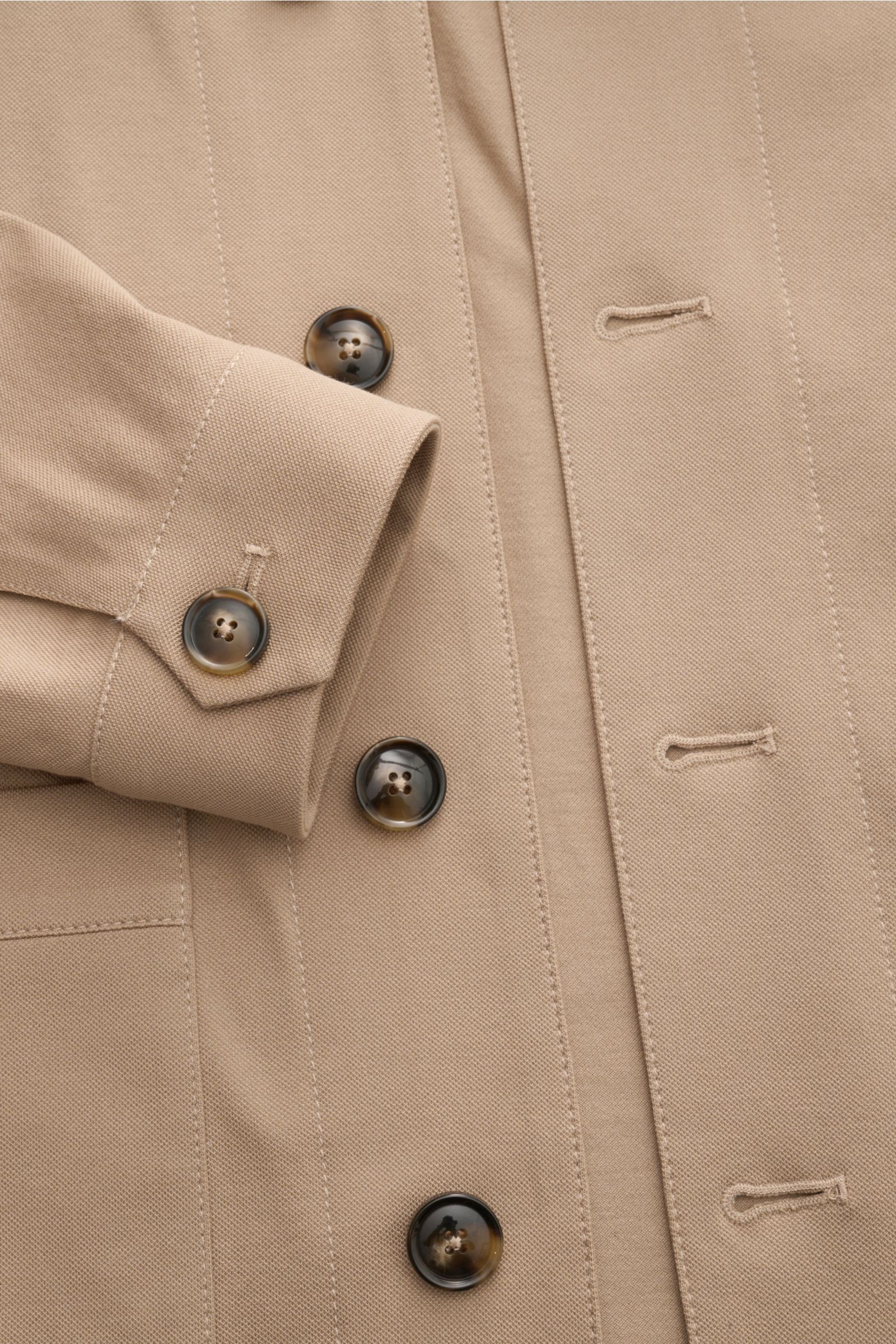 Nahaufnahme von Knöpfen und Manschette des Circolo 1901 Overshirt sand aus elastischer Baumwolle mit Slim Fit, Umlegekragen und Fronttaschen, fotografiert von oben.