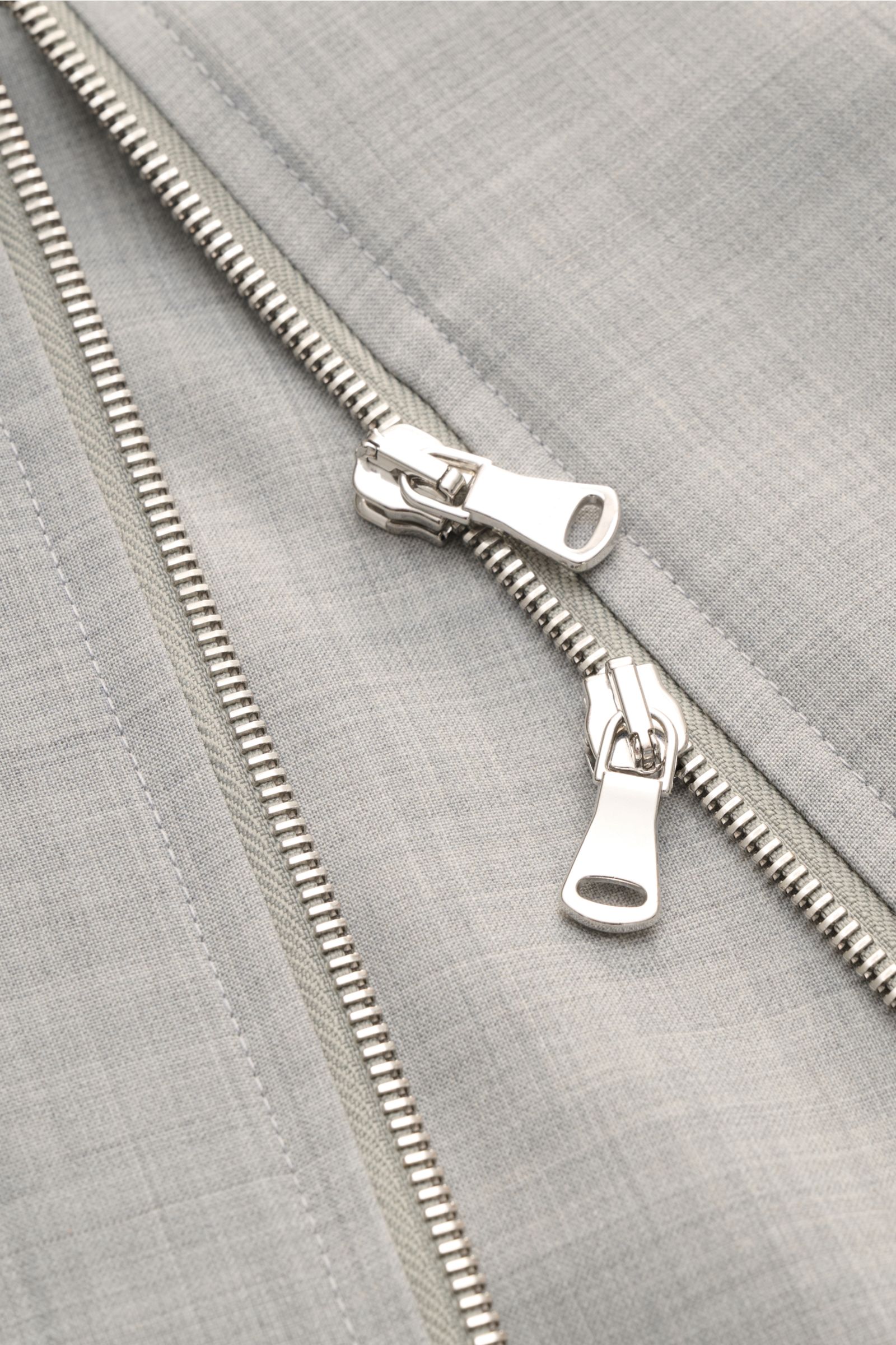 Close-up front view of the Briglia 1949 Overshirt 'Bill' grau meliert showing the two-way silver zipper on gray melange fabric. Italienisches Flair in Ihrer Garderobe erhalten Sie mit dem smarten Overshirt 'Bill' aus dem Hause BRIGLIA 1949: Ein klassische