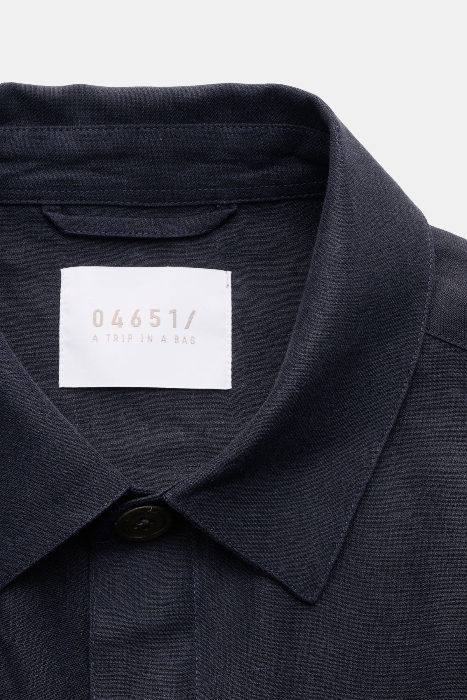 Nahaufnahme des Kragens von 04651/ A trip in a bag Overshirt 'Linen Jacket' navy aus reinem Leinen, Slim Fit, mit Umlegekragen, weichem Griff, fotografiert von vorne.