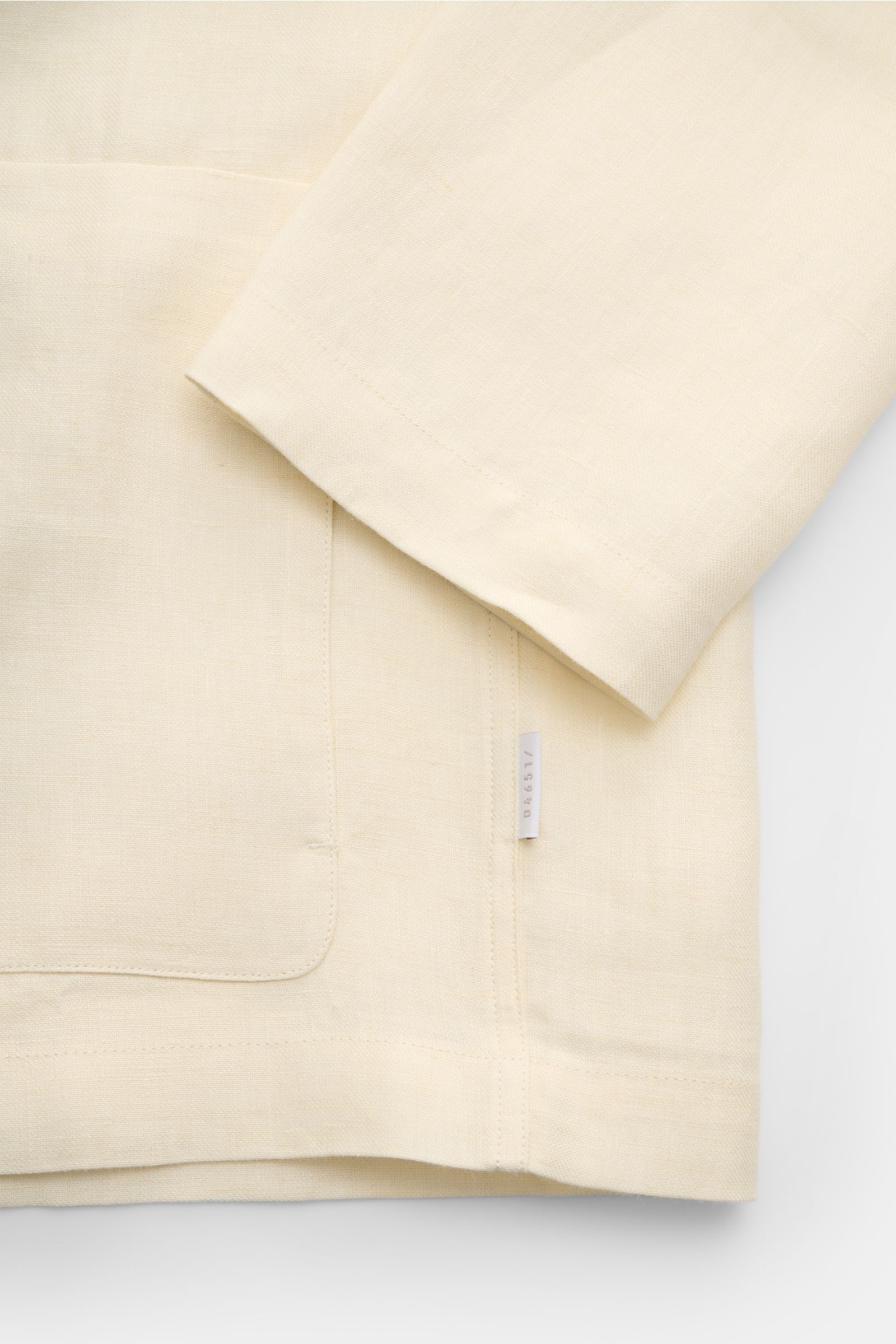 Close-up view of the sleeve and lower front pocket area of the 04651/ A trip in a bag Overshirt 'Linen Jacket' cream, showcasing pure linen fabric with a soft feel and slim fit design. For casual linen looks: This overshirt by 04651/ A TRIP IN A BAG is ma