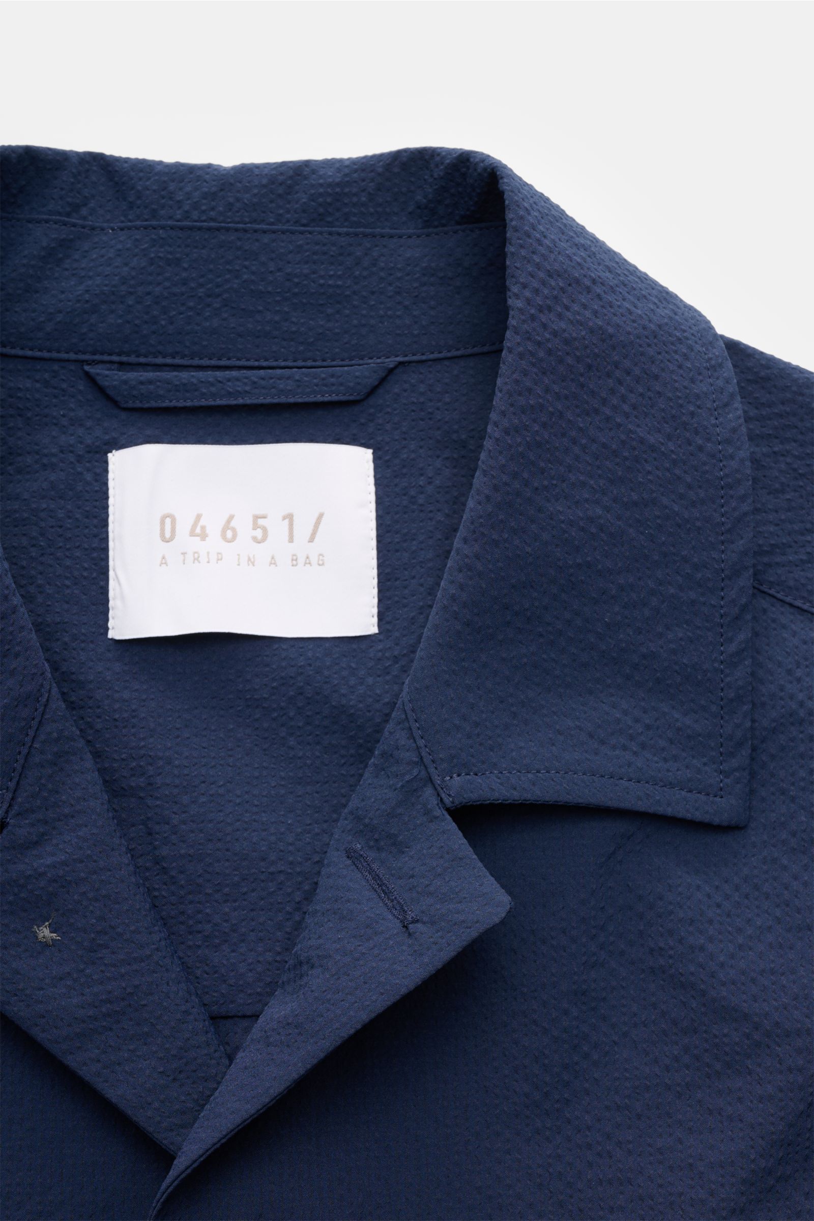 Nahaufnahme des navyfarbenen 04651/ A trip in a bag Overshirt 'Technical Seersucker' mit Umlegekragen und strukturierter Microfaser, Slim Fit, aus frontaler Perspektive.