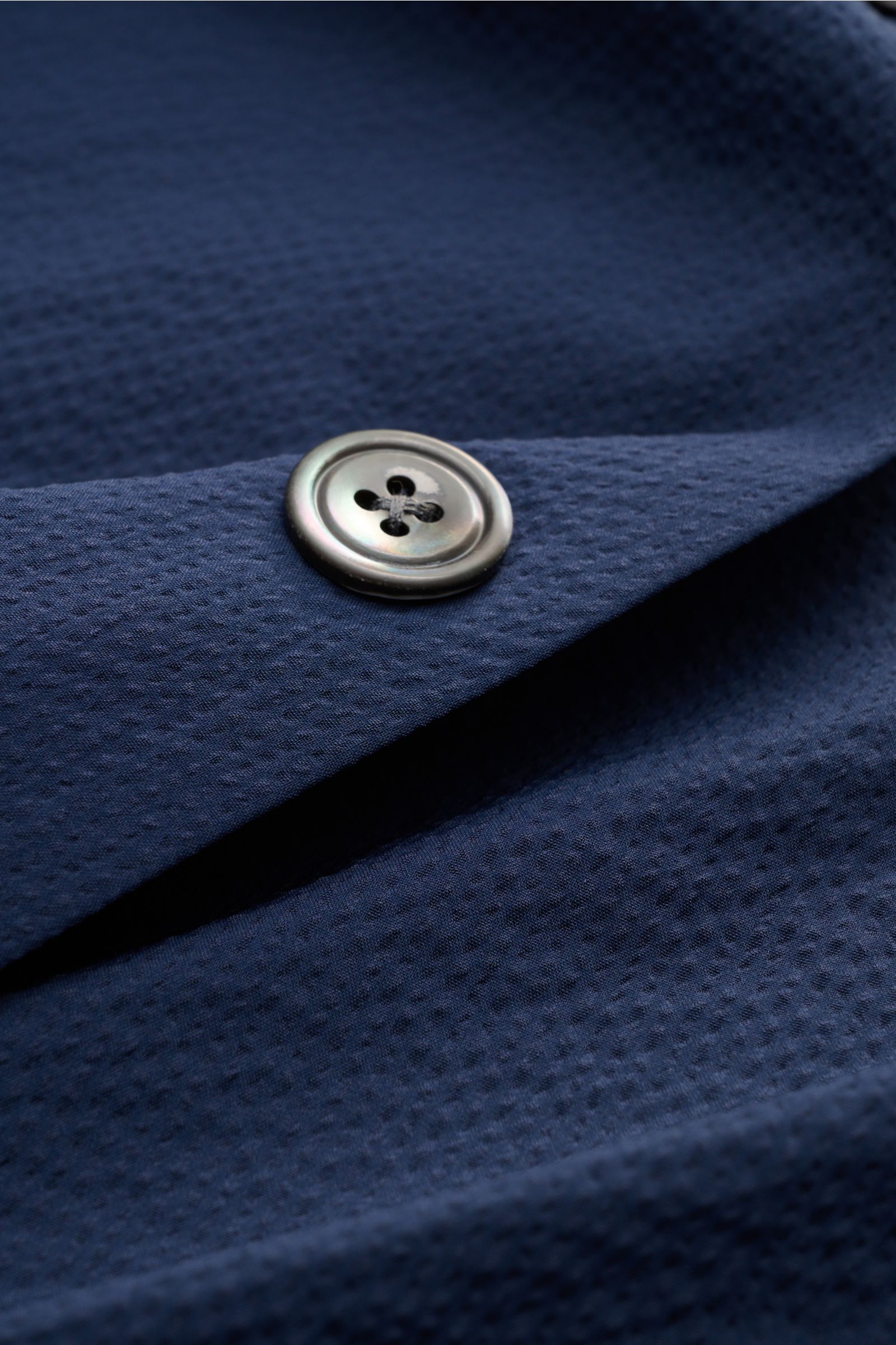 Nahaufnahme des navyfarbenen 04651/ A trip in a bag Overshirt 'Technical Seersucker' mit Struktur, Knopf, Slim Fit, Microfaser.